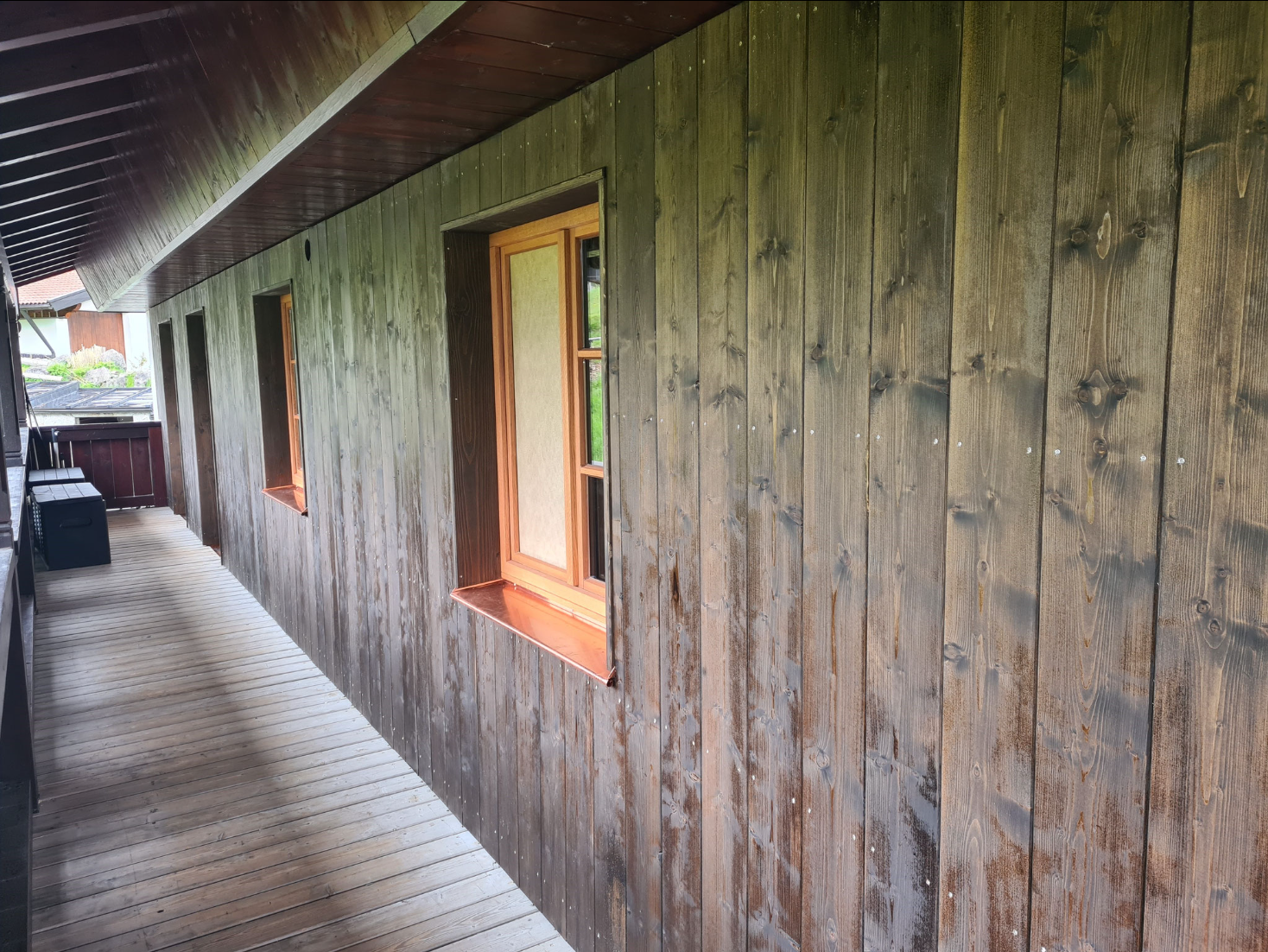 Holzverschattete Außenveranda mit Fenster und Holzverkleidung