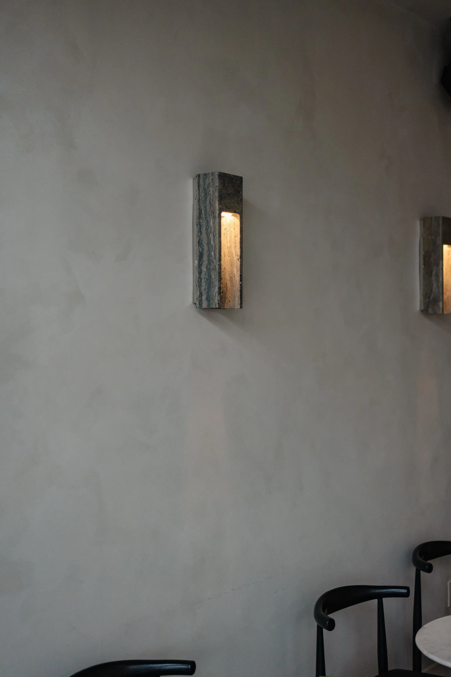 Wall-mounted modern light fixtures in a minimalist interior setting.