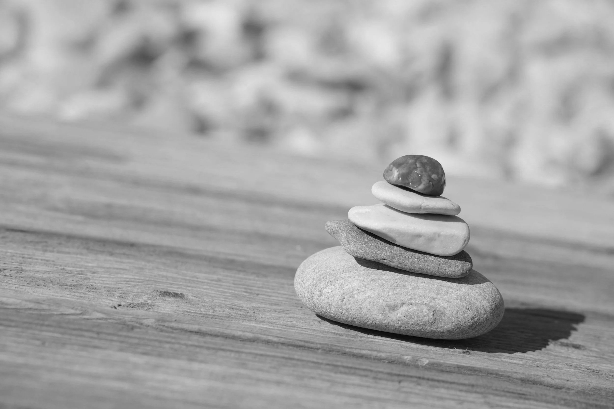 Black and white image of stacked stones in careful balance, symbolising clear standards, alignment, and intentional relationship choices.