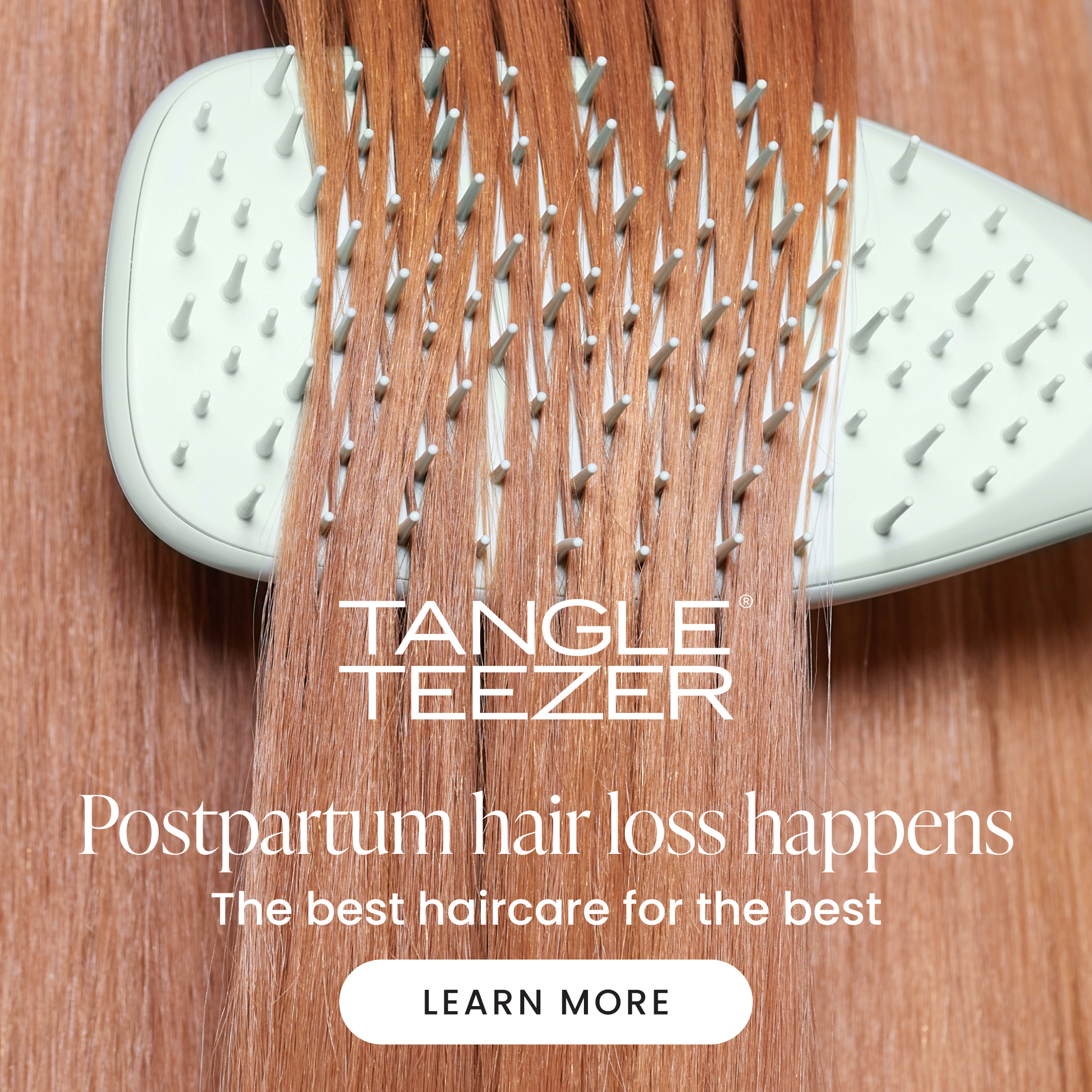 Close-up of a hairbrush in brunette hair with hair strands sitting in the brush and text overlay about postpartum hair loss.