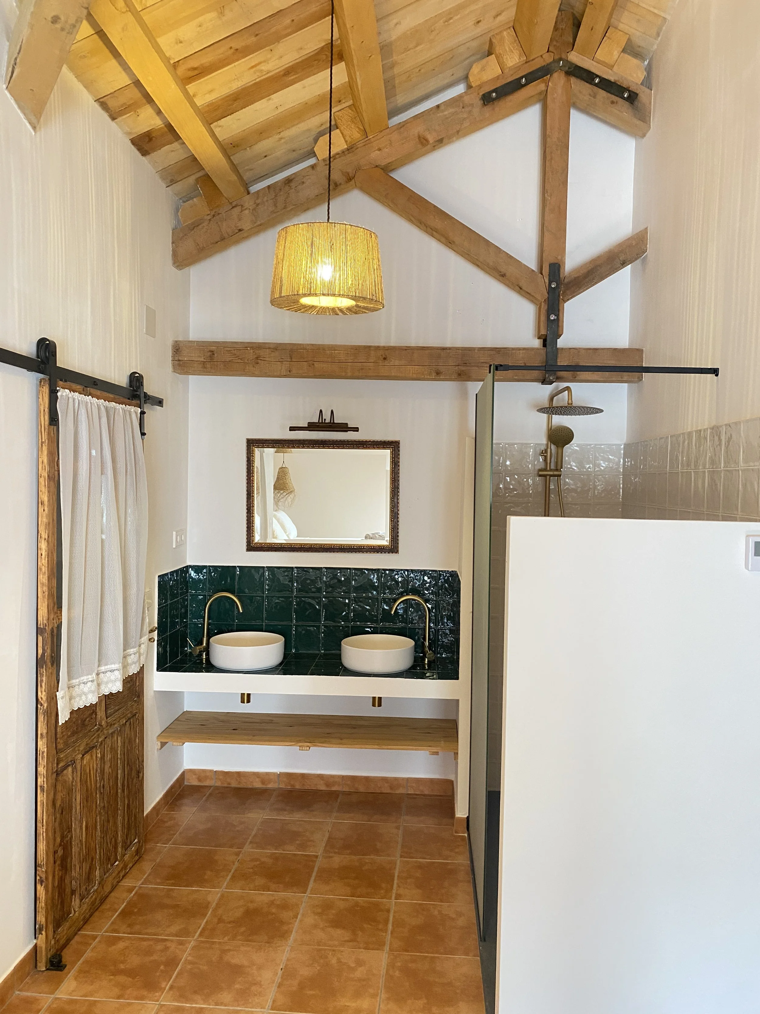 Baño privado con doble lavabo y acabados artesanales 