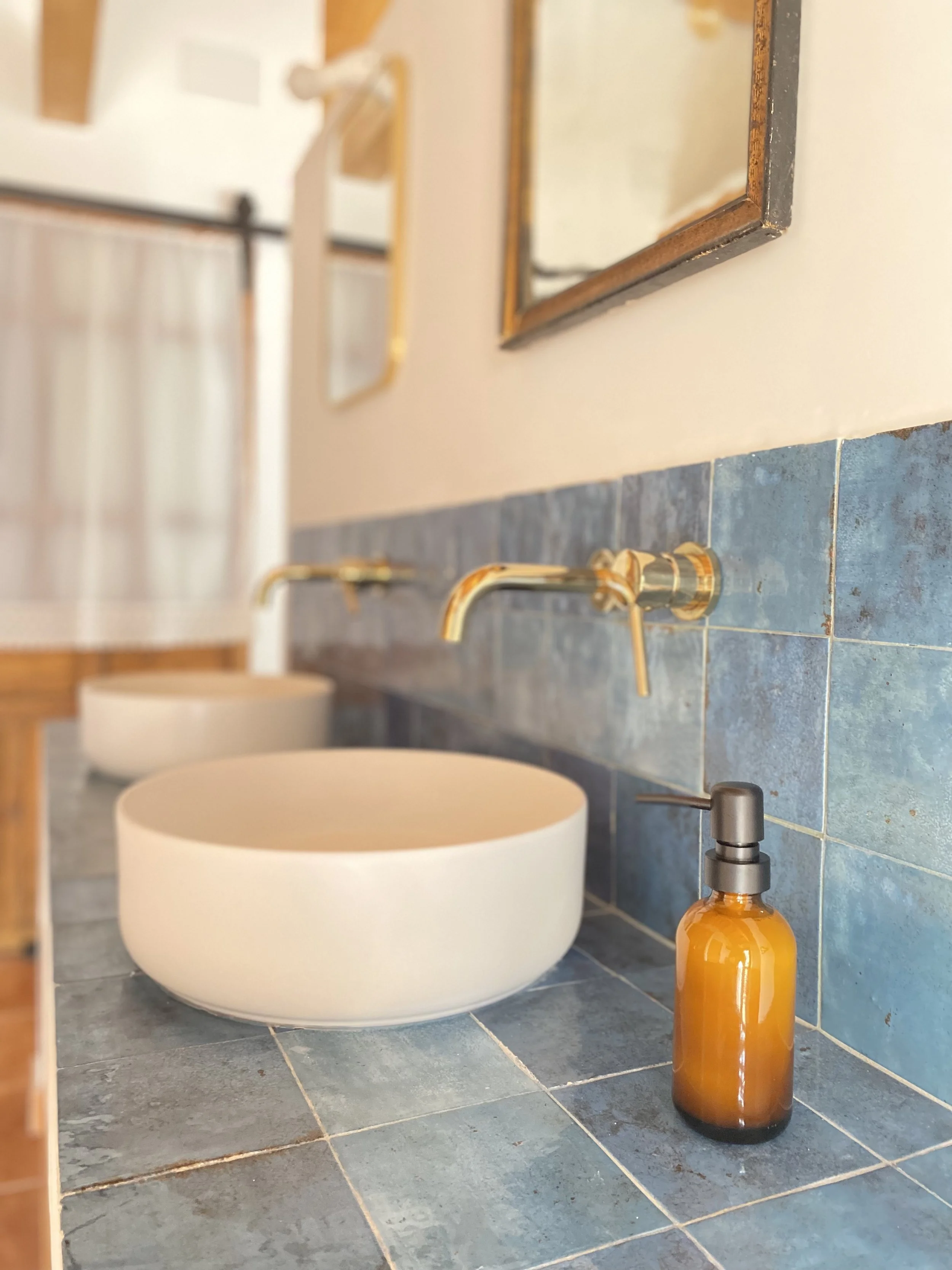Detalle de lavabo de diseño con grifería en acabado dorado