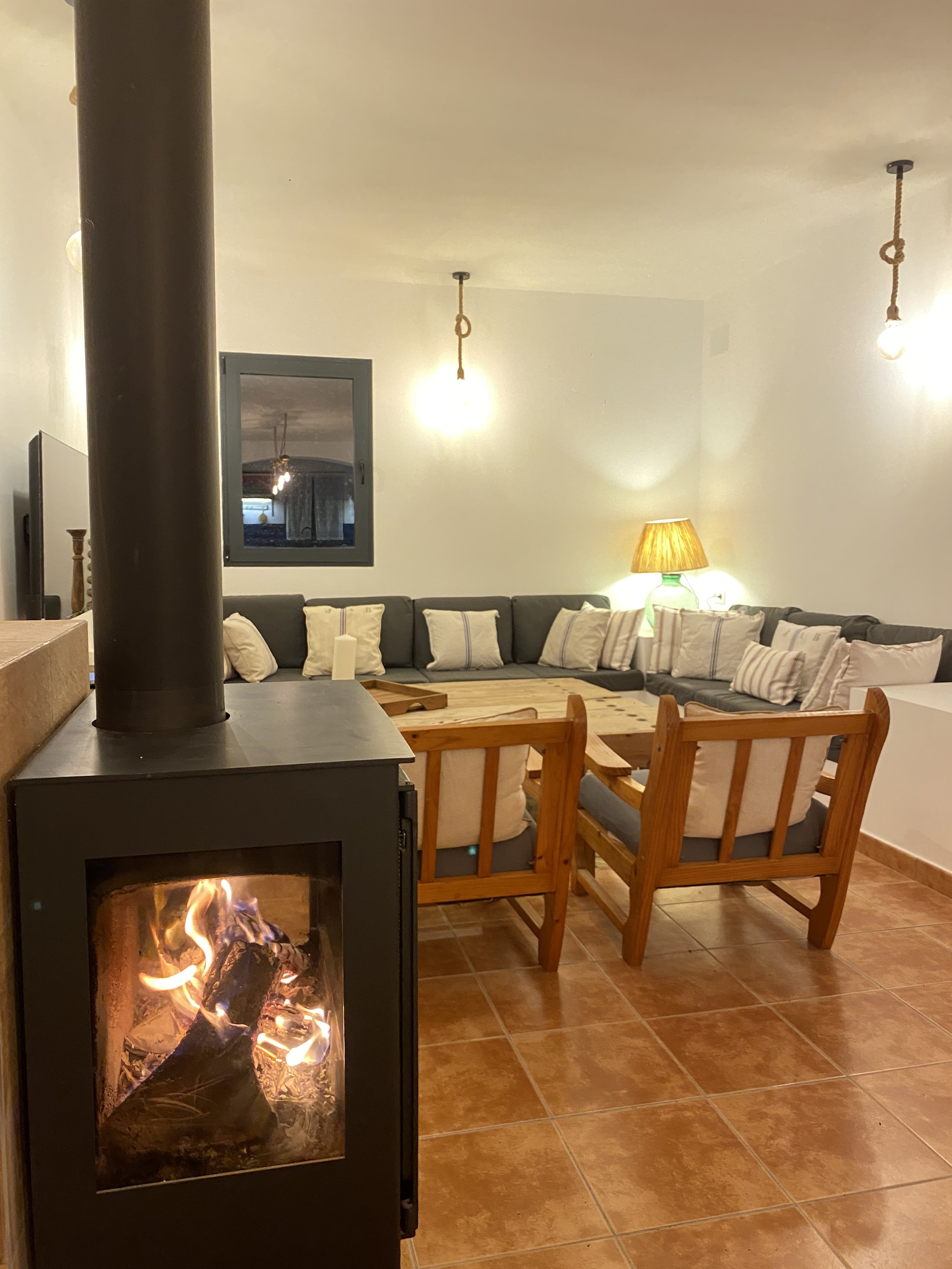 Salón con chimenea de leña y decoración rústica en casa rural en Toledo