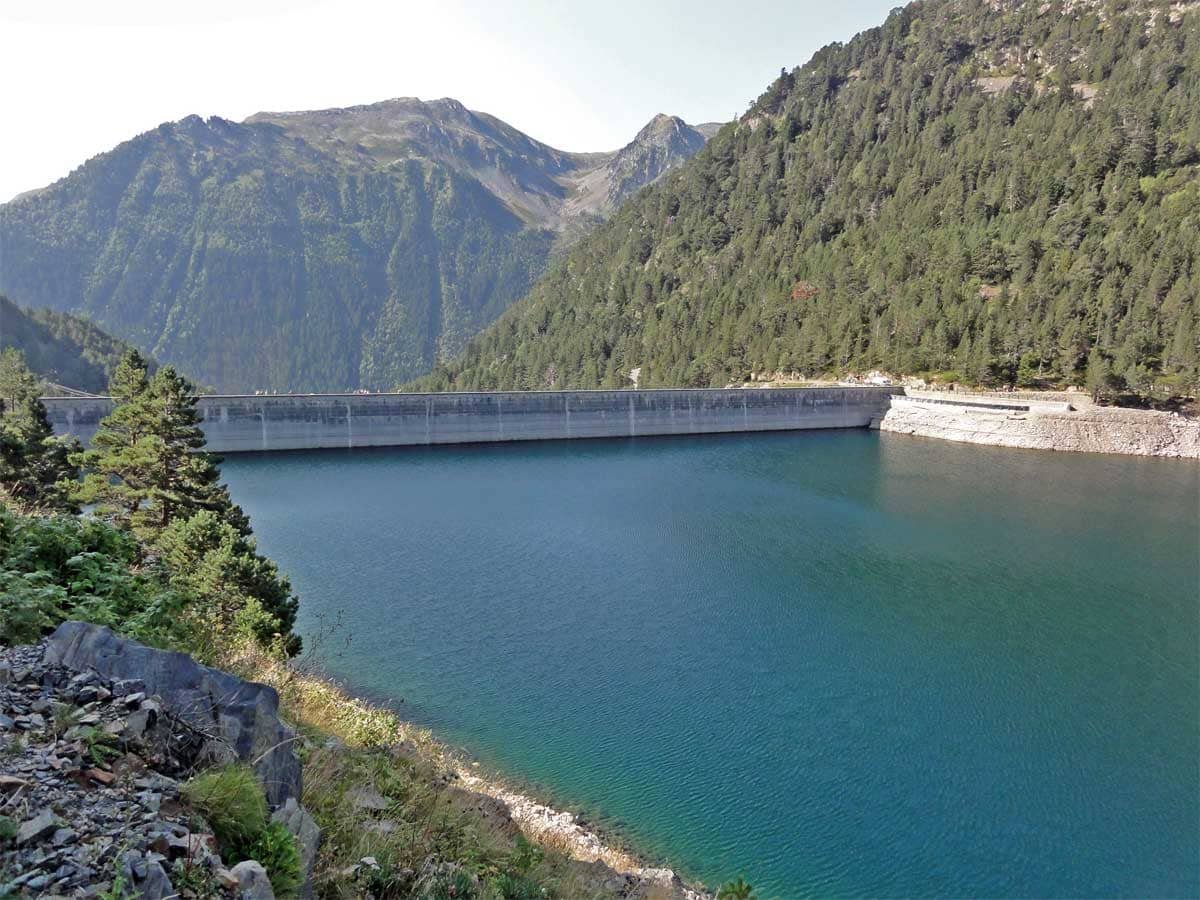 Lac de montagne entouré de forêts et de montagnes.
