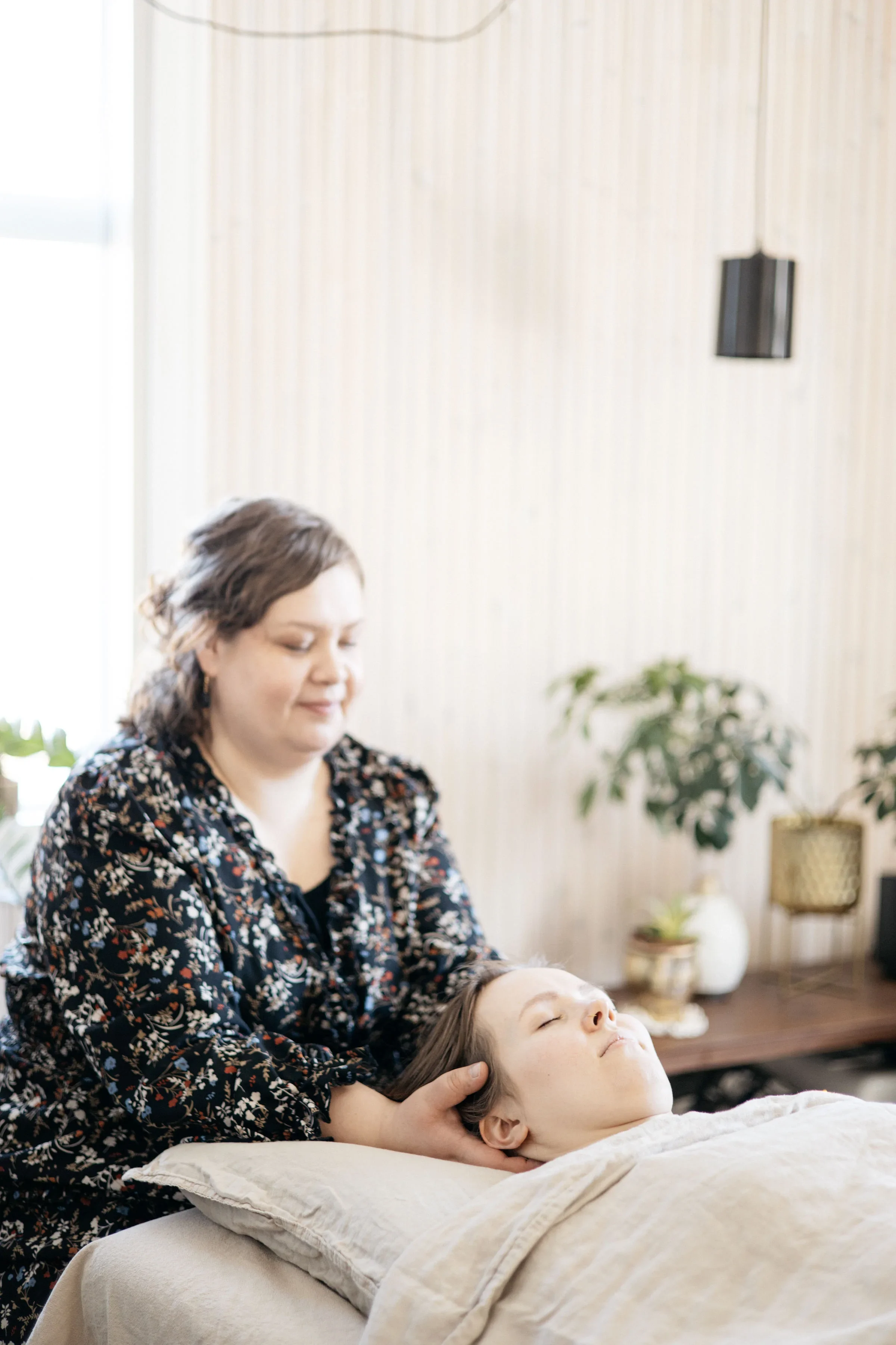 Lempeää vyöhyketerapiaa, asiakas lepää silmät kiinni hoitopöydällä