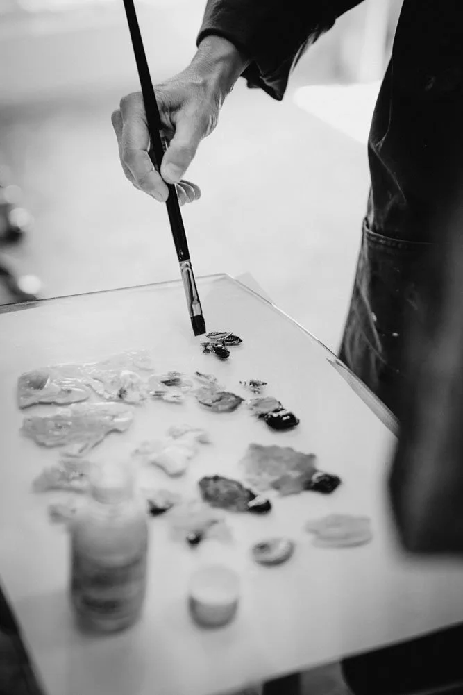 Malerin Damaris Tobler mischt mit dem Pinsel Farben auf ihrer Palette in ihrem Atelier in Urnäsch im Appenzellerland.