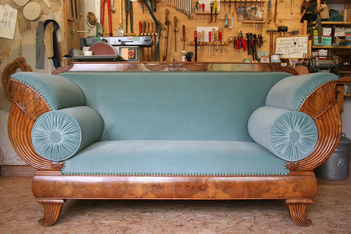 Inspiration zur Möbelrestaurierung: Aufwendig restauriertes antikes Sofa mit geschnitztem Holzrahmen und hellblauer Polsterung – traditionelles Polsterhandwerk für historische Lieblingsstücke.