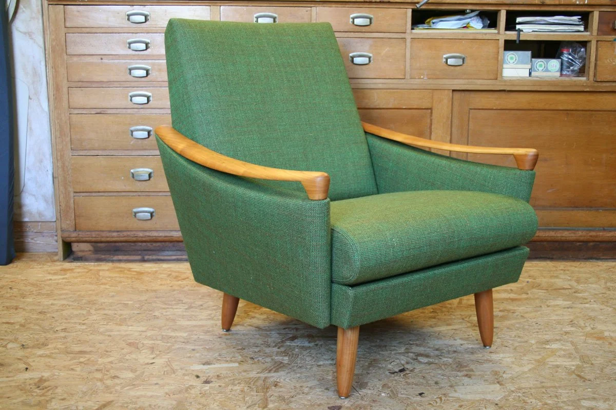 Inspiration aus der Polsterei Urnäsch: Neu gepolsterter Vintage-Sessel mit grünem Stoffbezug, Holzarmlehnen und schlanken Holzfüssen.