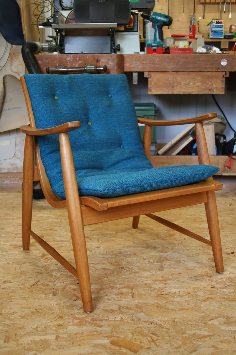 Leichter Holzsessel mit neuem blauem Polster – ein Beispiel für die Verbindung von klassischem Möbeldesign und individuellem Polsterhandwerk in der Ostschweiz.