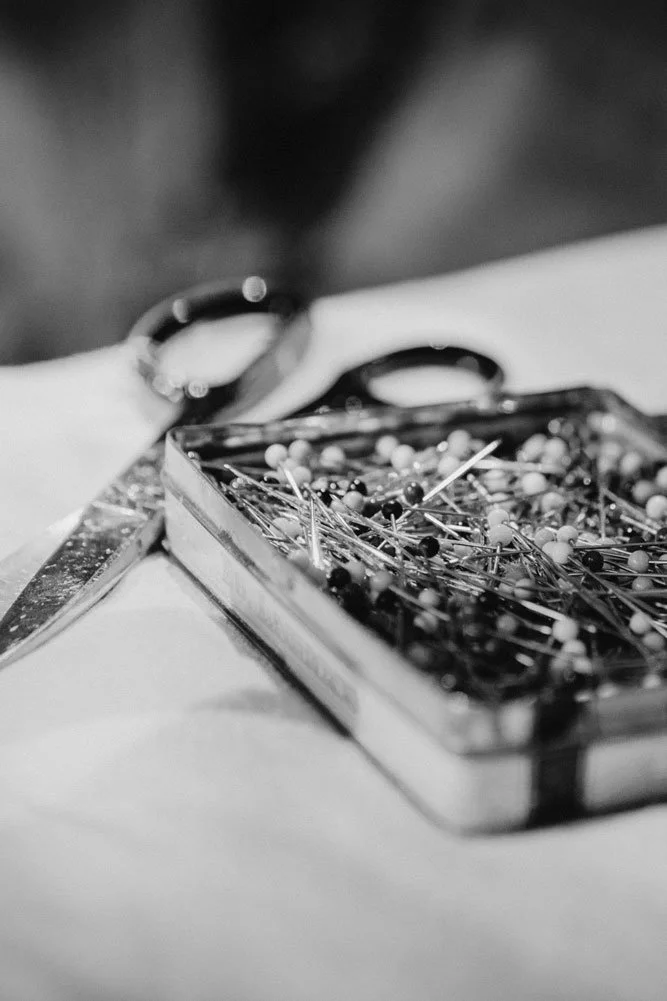 Stecknadeln und Schere auf dem Arbeitstisch einer traditionellen Polsterei – Handwerkszeug zum Zuschneiden, Fixieren und Beziehen von Polstermöbeln in der Saienbrücke in Urnäsch.