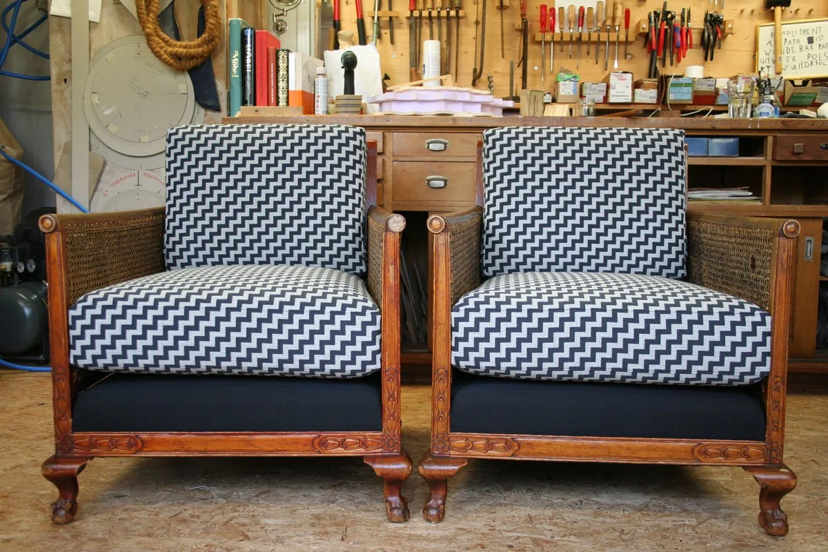 Möbel restaurieren in der Ostschweiz: Zwei historische Armlehnsessel mit Holzgestell, neu gepolstert und mit grafischem Schwarz-Weiss-Stoff bezogen.