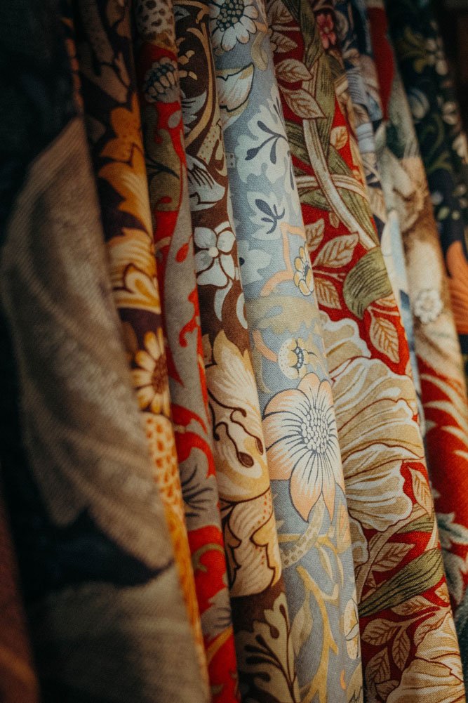 Auswahl kunstvoller floraler Möbelstoffe im Arts-and-Crafts-Stil – besondere Bezugsstoffe, um antike Sessel und alte Lieblingsmöbel stilgerecht neu zu polstern.