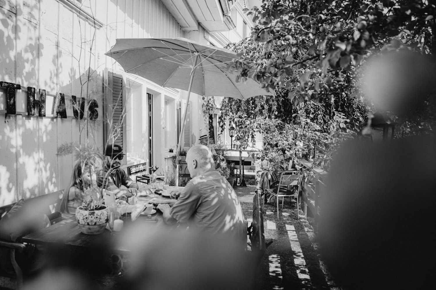 Kaffee Appenzell: Gäste sitzen unter Bäumen vor dem Café Saienbrücke in Urnäsch – ein lauschiger Ort zum Kaffeetrinken und Verweilen.