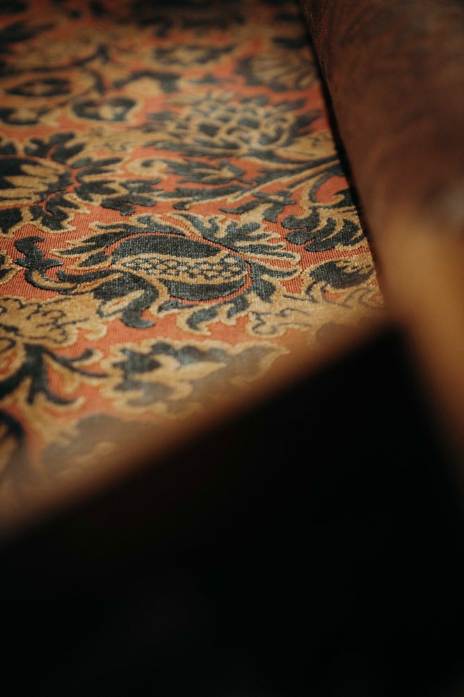 Detail eines kunstvoll gemusterten Bezugsstoffs für die stilgerechte Restaurierung und Neupolsterung von antiken Möbeln und Lieblingsstücken.