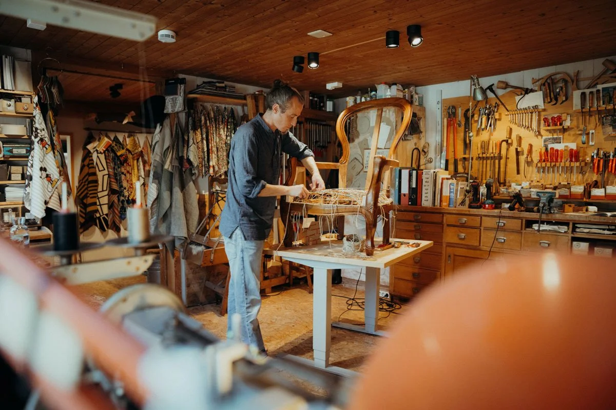Simon Tobler bei der Restaurierung eines antiken Stuhls in seiner Polsterei in Urnäsch im Appenzellerland.