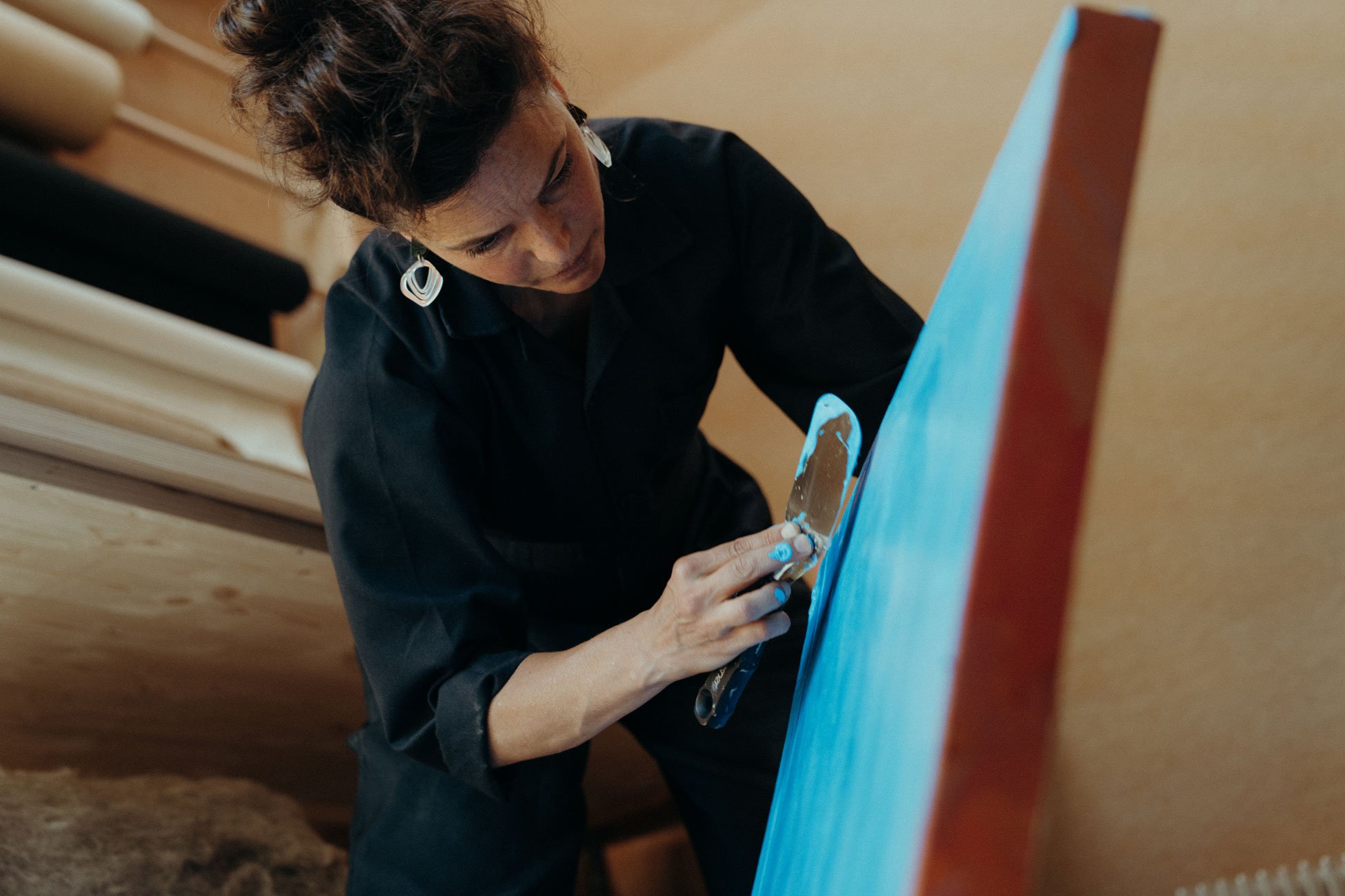 Damaris Tobler beim Auftragen leuchtender Farbe auf ein grossformatiges Werk – ein Einblick in ihr künstlerisches Schaffen im Atelier Saienbrücke in Urnäsch.