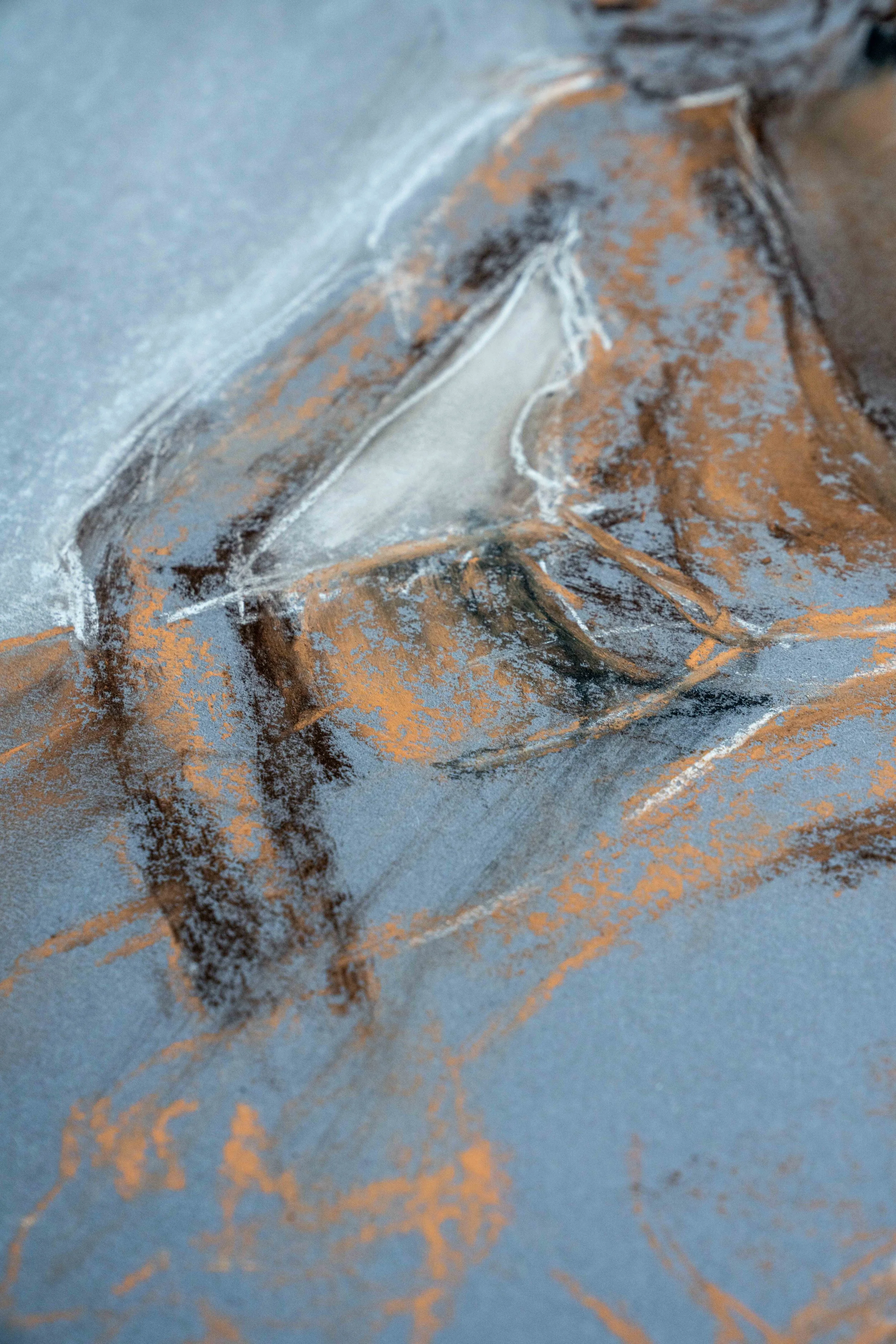 Detail einer figurativen Körperstudie auf blauem Papier. Damaris Tobler kombiniert orangefarbene Kreidelinien, dunkle Schraffuren und weisse Akzente – eine vielschichtige Technik für das Zeichnen und Modellieren des menschlichen Körpers.