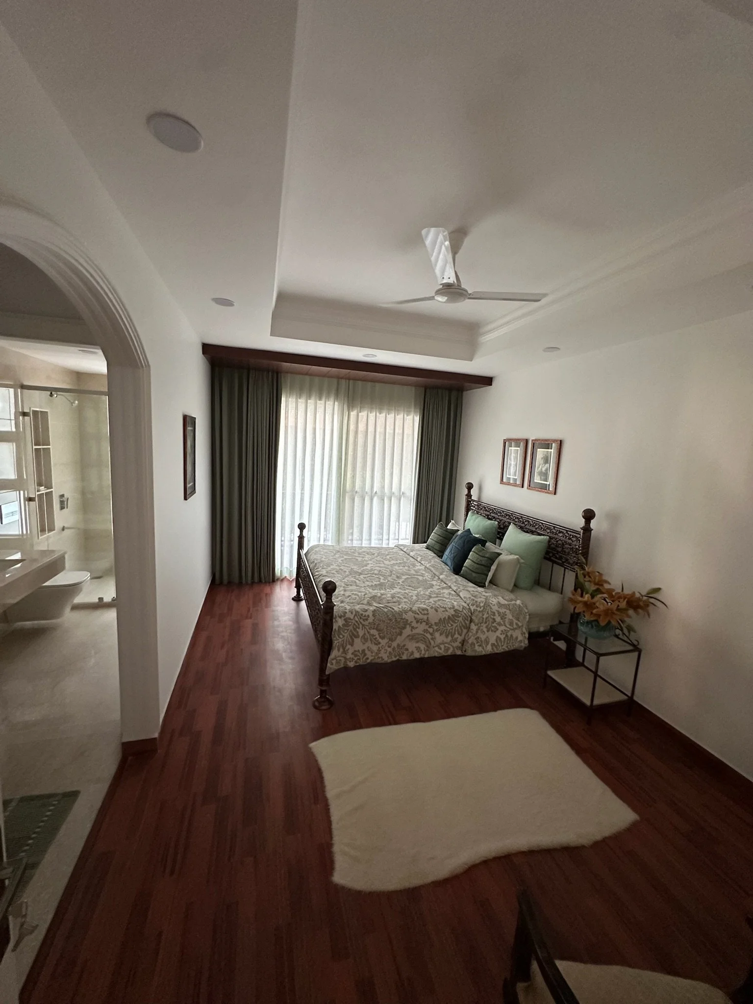 View of an entryway with an archway, mirror on the wall, and a sliding closet door.