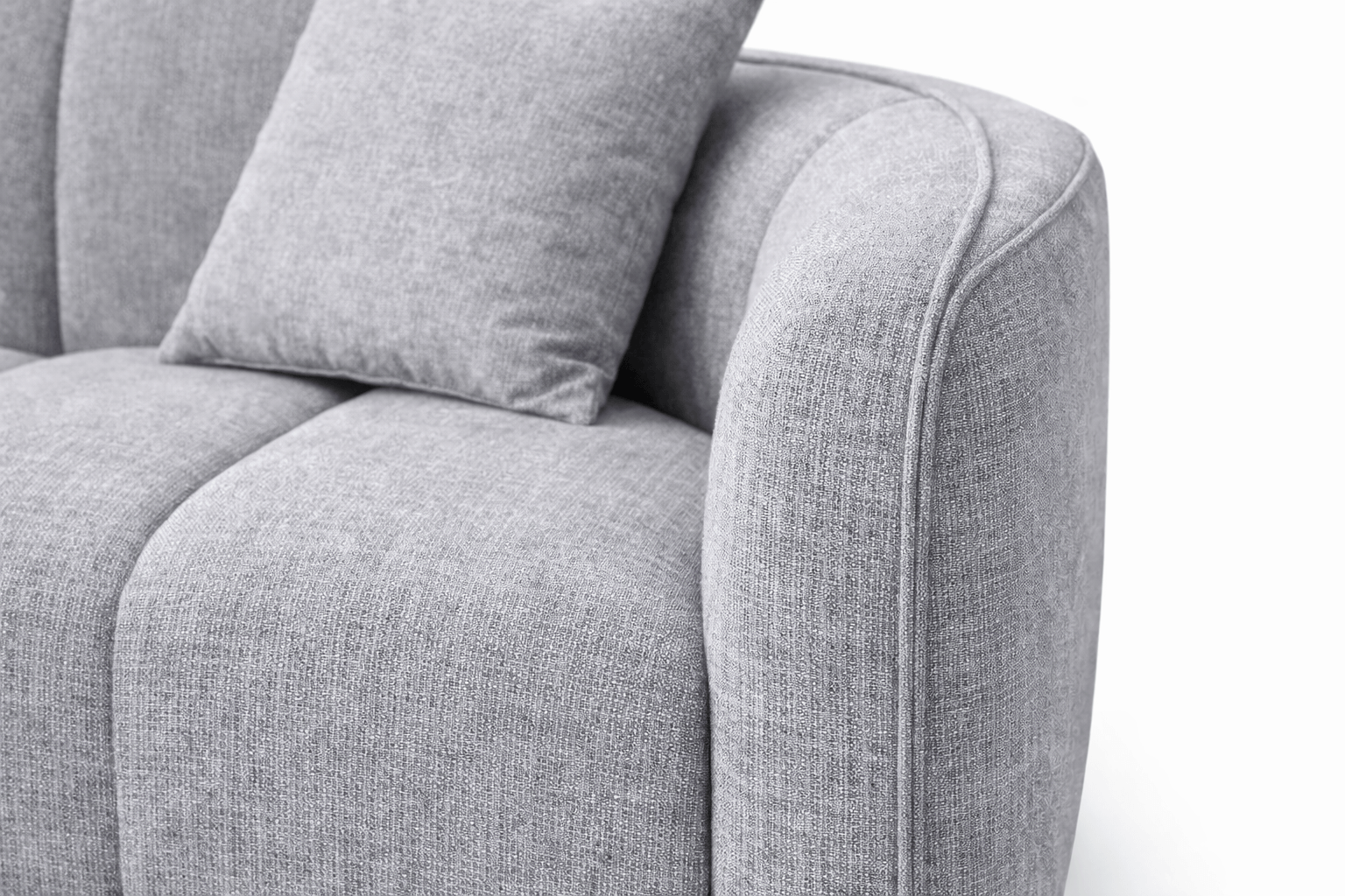 Close-up of a light gray upholstered sofa with a matching cushion, showing detailed fabric texture and piping along the armrest.