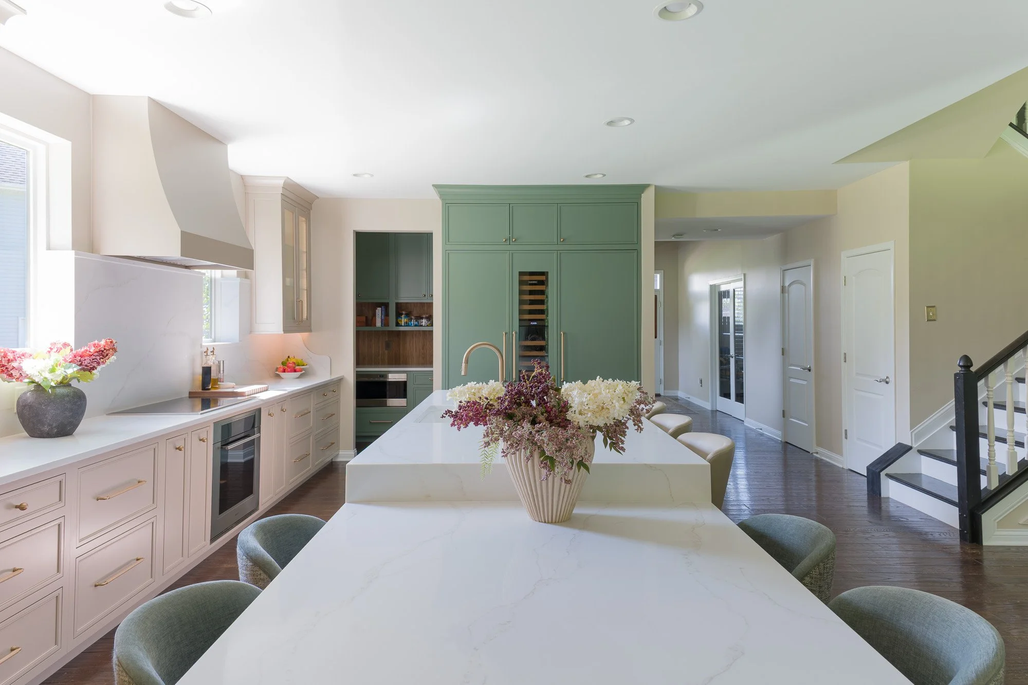 Quartz counters: Quartz countertops with taupe veining and a full countertop backsplash by White Oak Interiors