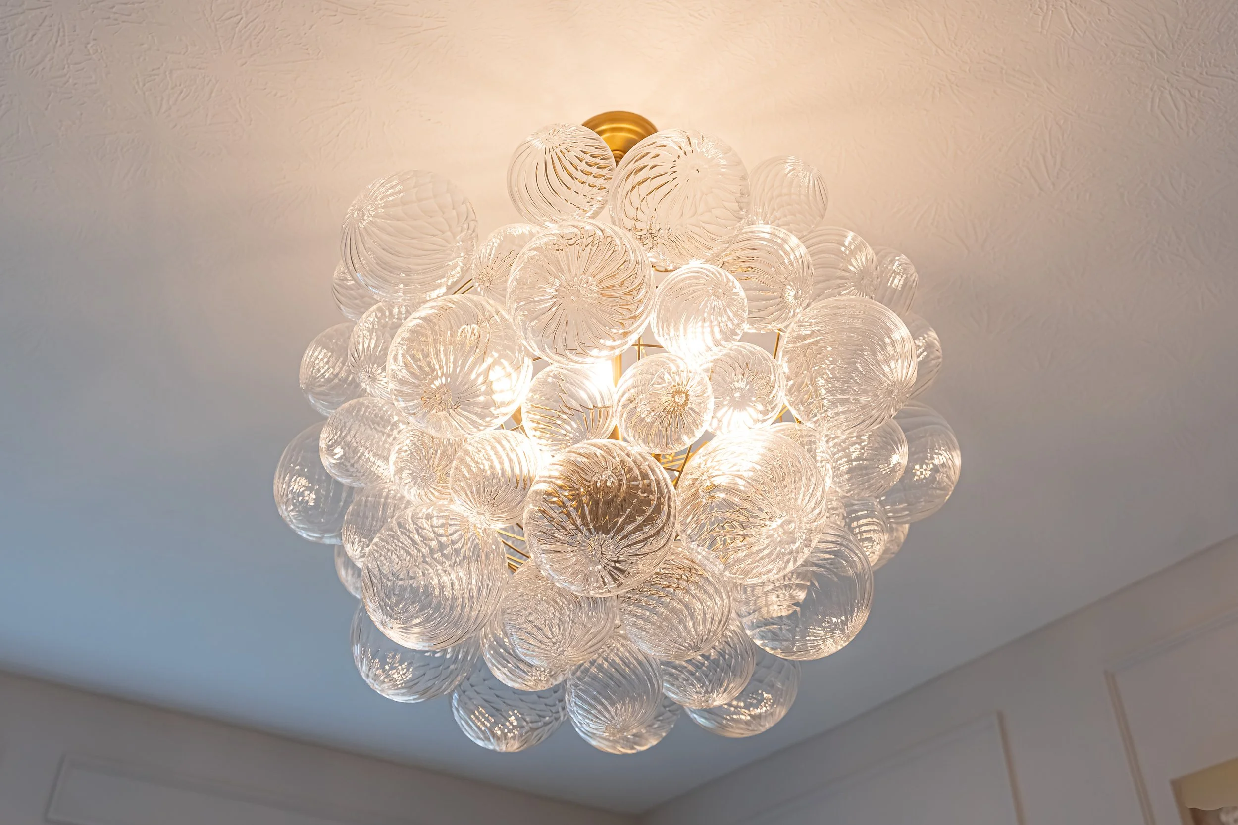 Detail of a clustered glass globe chandelier in a Centerville home renovation.