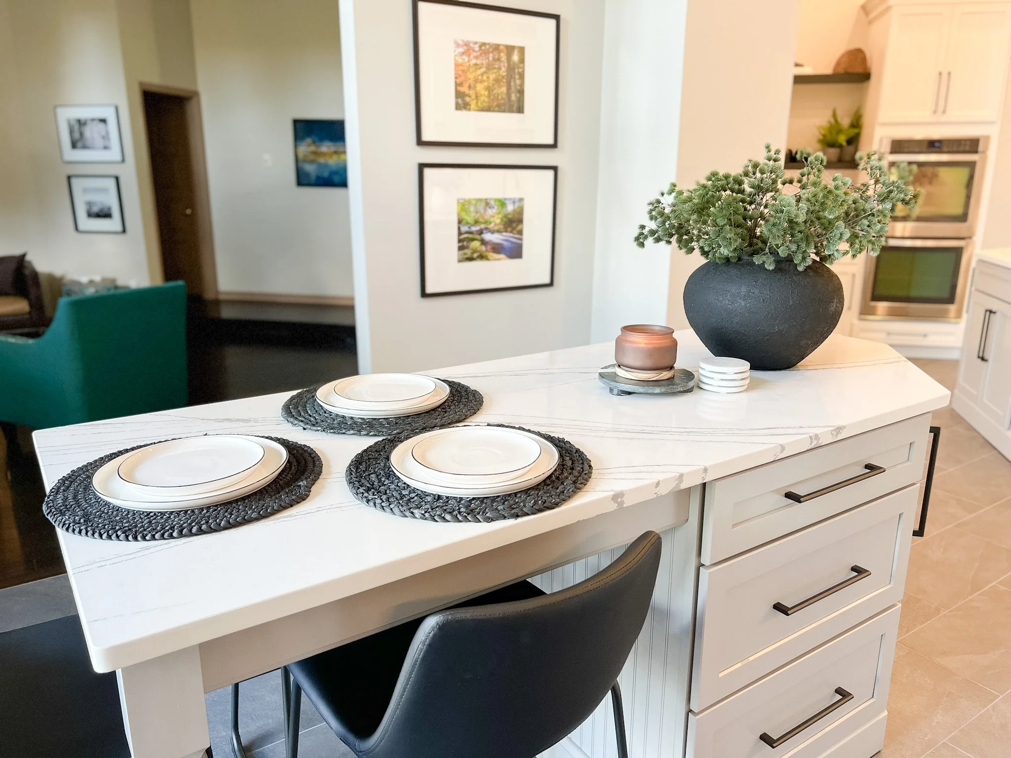 Marble-topped eat-in island with seating, a framed gallery wall, and an adjoining dining area in a Centerville, Ohio renovation