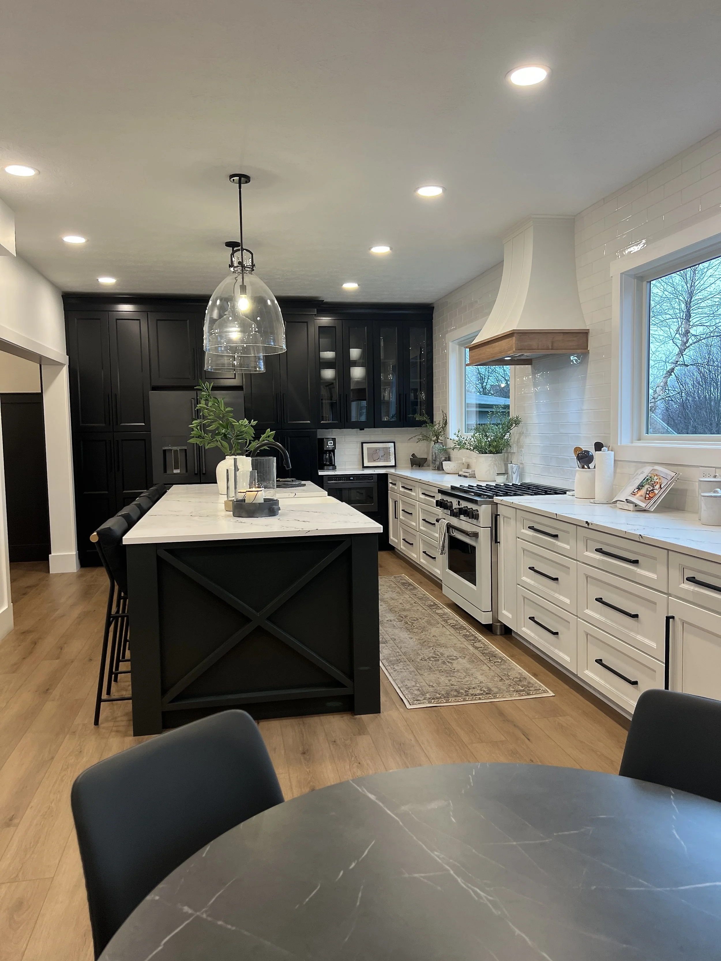 Two-tone kitchen with a custom plaster range hood, white and dark cabinetry, a green island, and stainless range in a Springboro, Ohio renovation