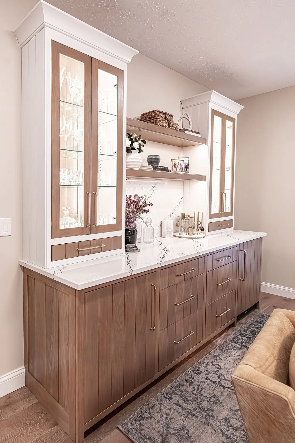 Custom white oak wine bar with glass-front display cabinets, Cambria quartz countertop and matching backsplash in an Oakwood, Ohio home