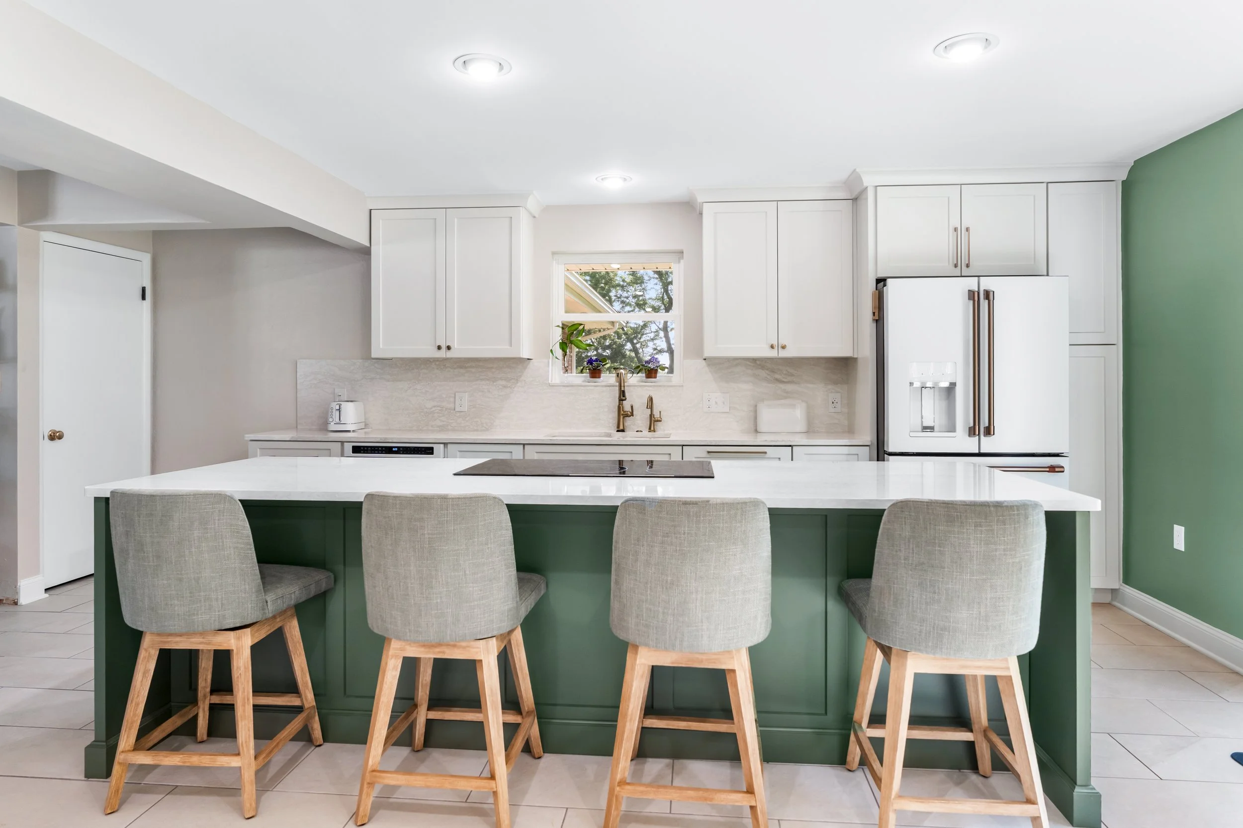Custom kitchen remodel in Springfield, Ohio with an evergreen island, white perimeter cabinetry, gold accents, and wood-tone seating by White Oak Interiors