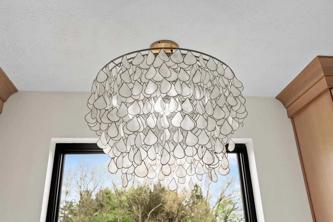Beaded teardrop chandelier in front of a window in a Brookville, Ohio master bathroom.