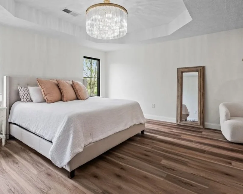 Master bedroom with a platform bed, beaded drum chandelier, and a leaning floor mirror in a Brookville, Ohio master suite renovation.