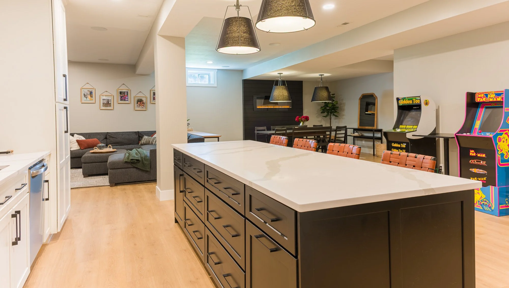Open basement living and media space with seating, island, and game area in Beavercreek, Ohio