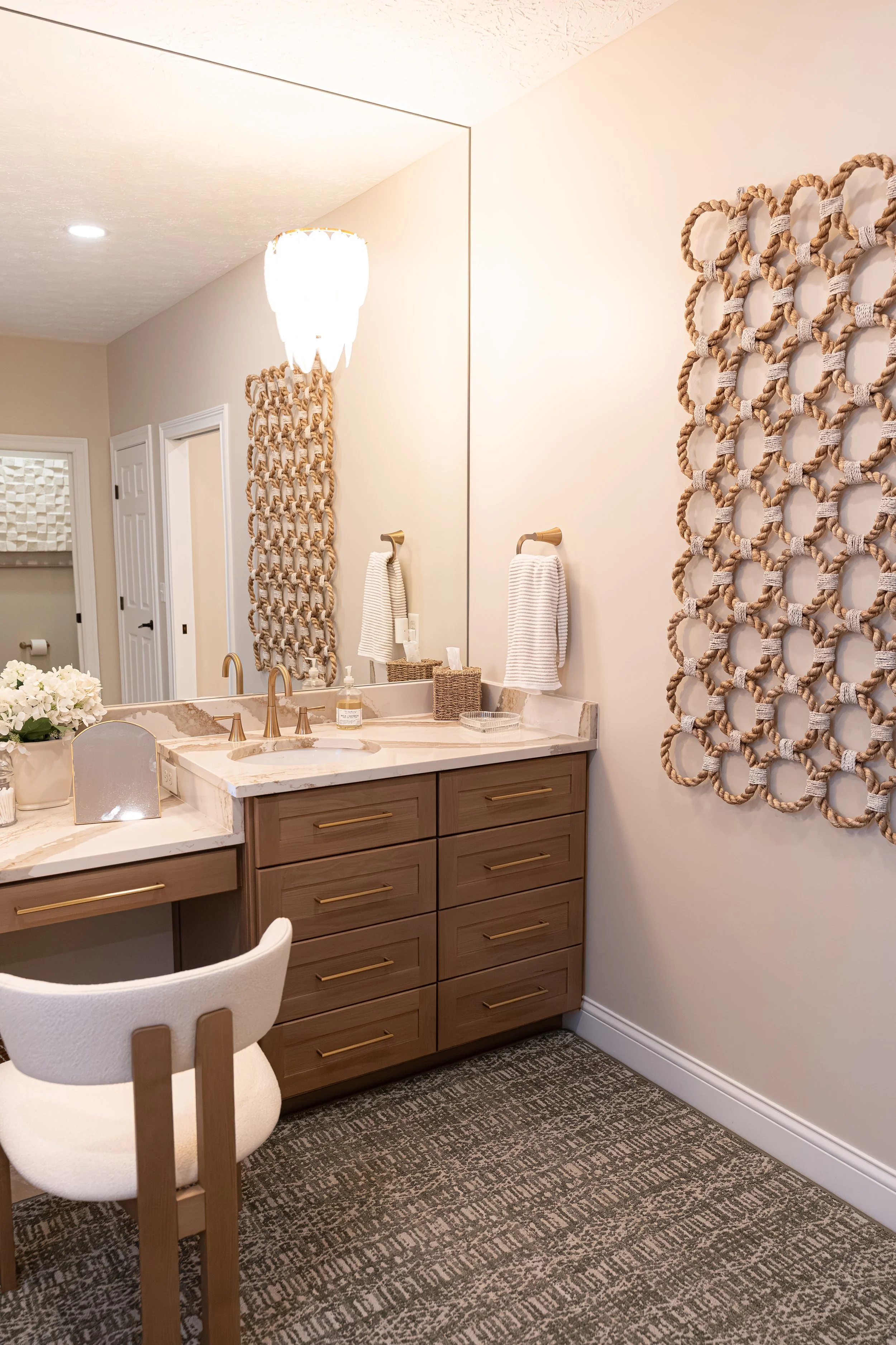 Master bathroom with a white oak vanity, integrated makeup desk, quartz countertops, gold pendant lighting, and woven wall art in an Oakwood, Ohio renovation