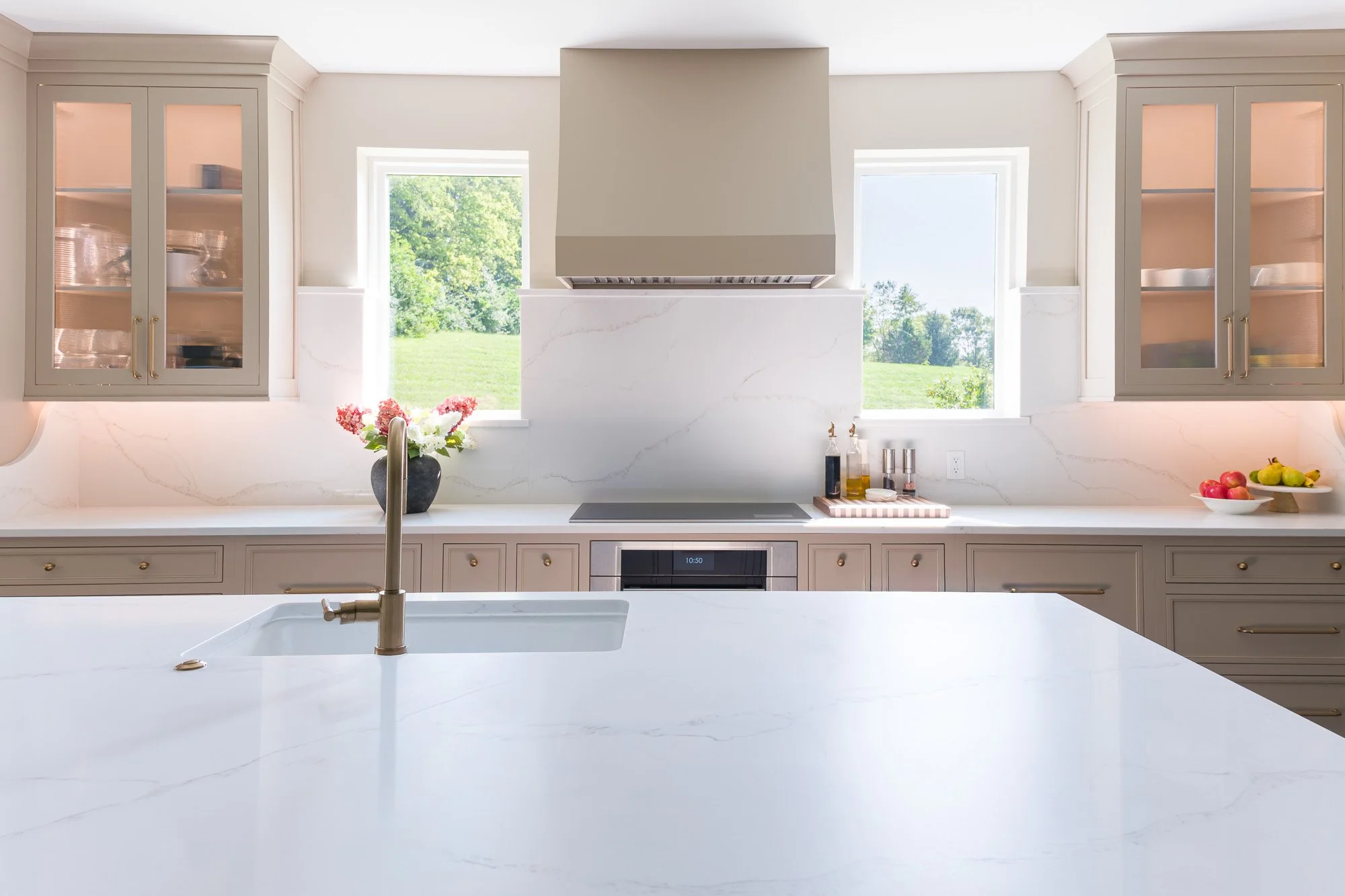 Quartz waterfall island flowing into a built-in dining table in a Dayton-area kitchen