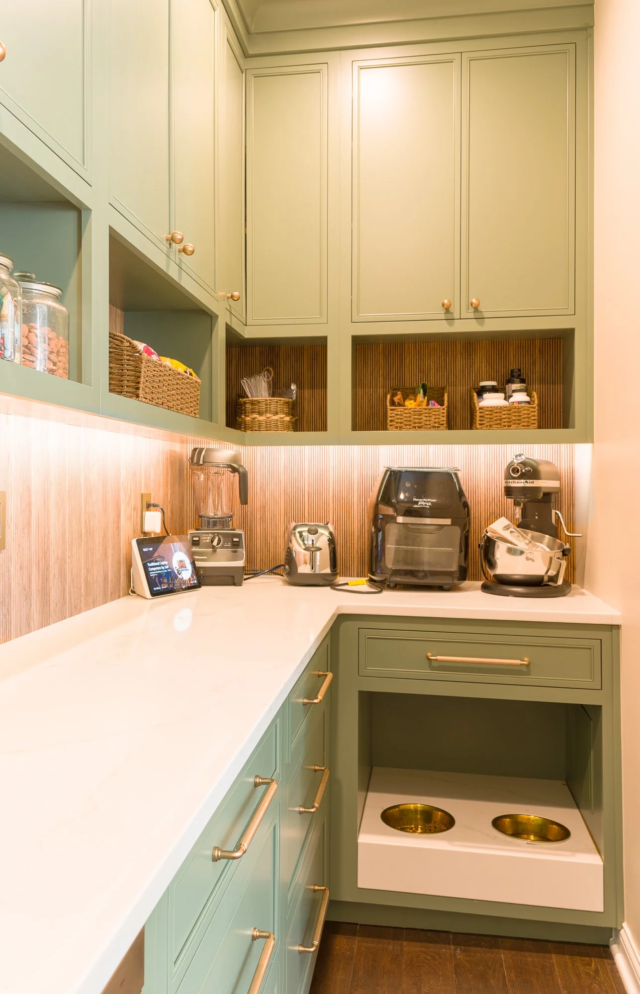 Dog station: Built-in dog water and food station with stone countertop in a custom kitchen pantry