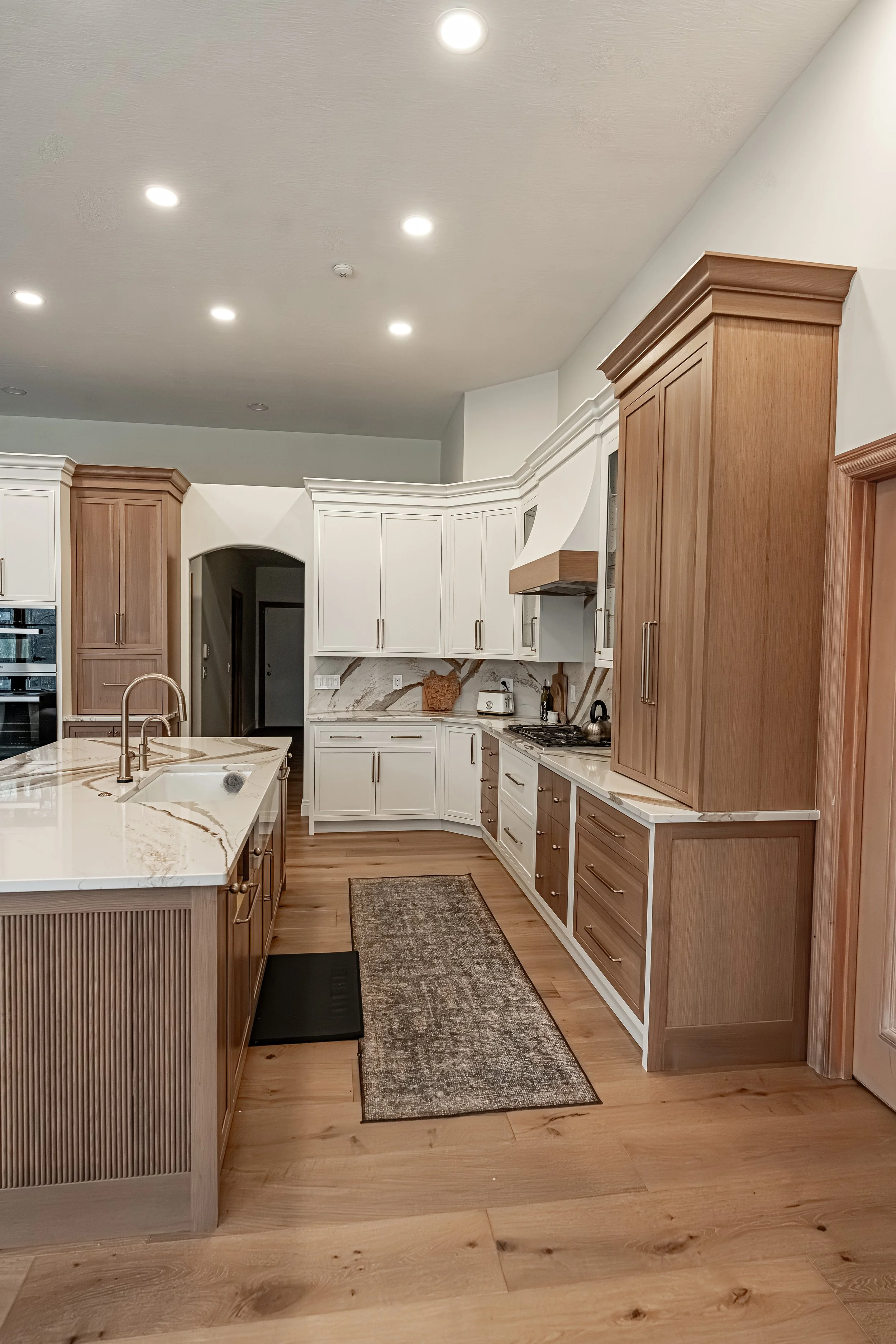 Bellbrook, Ohio kitchen remodel with fluted wood island, marble countertops, and white and natural wood cabinetry by White Oak Interiors