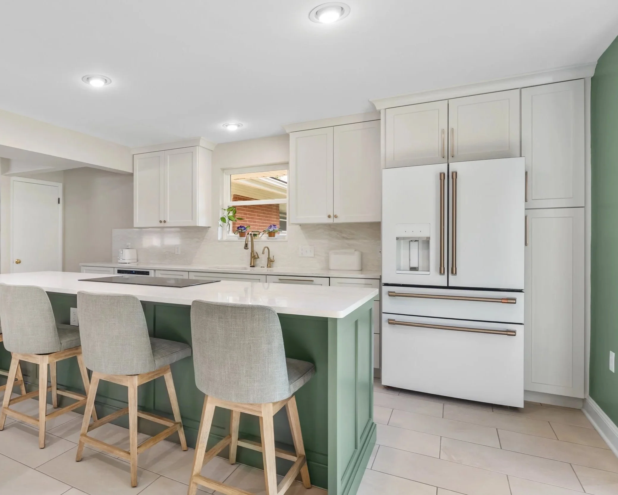 Springfield, Ohio kitchen remodel with an evergreen island, upholstered seating, and a gold-handled café refrigerator by White Oak Interiors