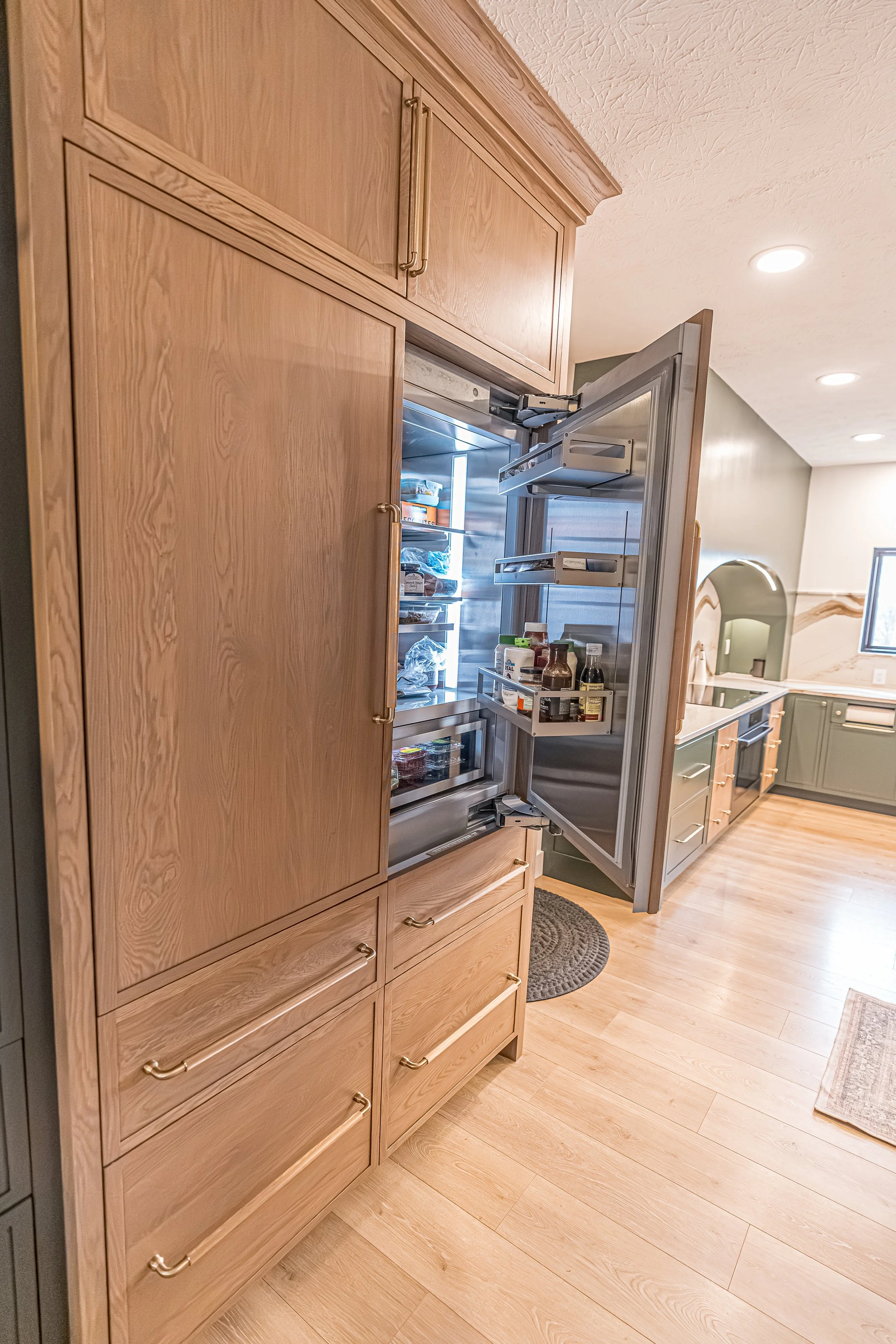 Panel-front built-in refrigerator integrated into white oak cabinetry in a remodeled Beavercreek kitchen