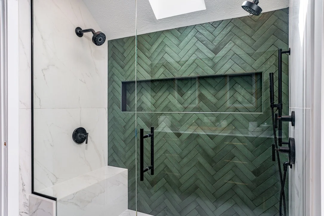 Walk-in shower with green herringbone tile, marble surround, and matte-black fixtures in a Dayton, Ohio master bathroom renovation by White Oak Interiors