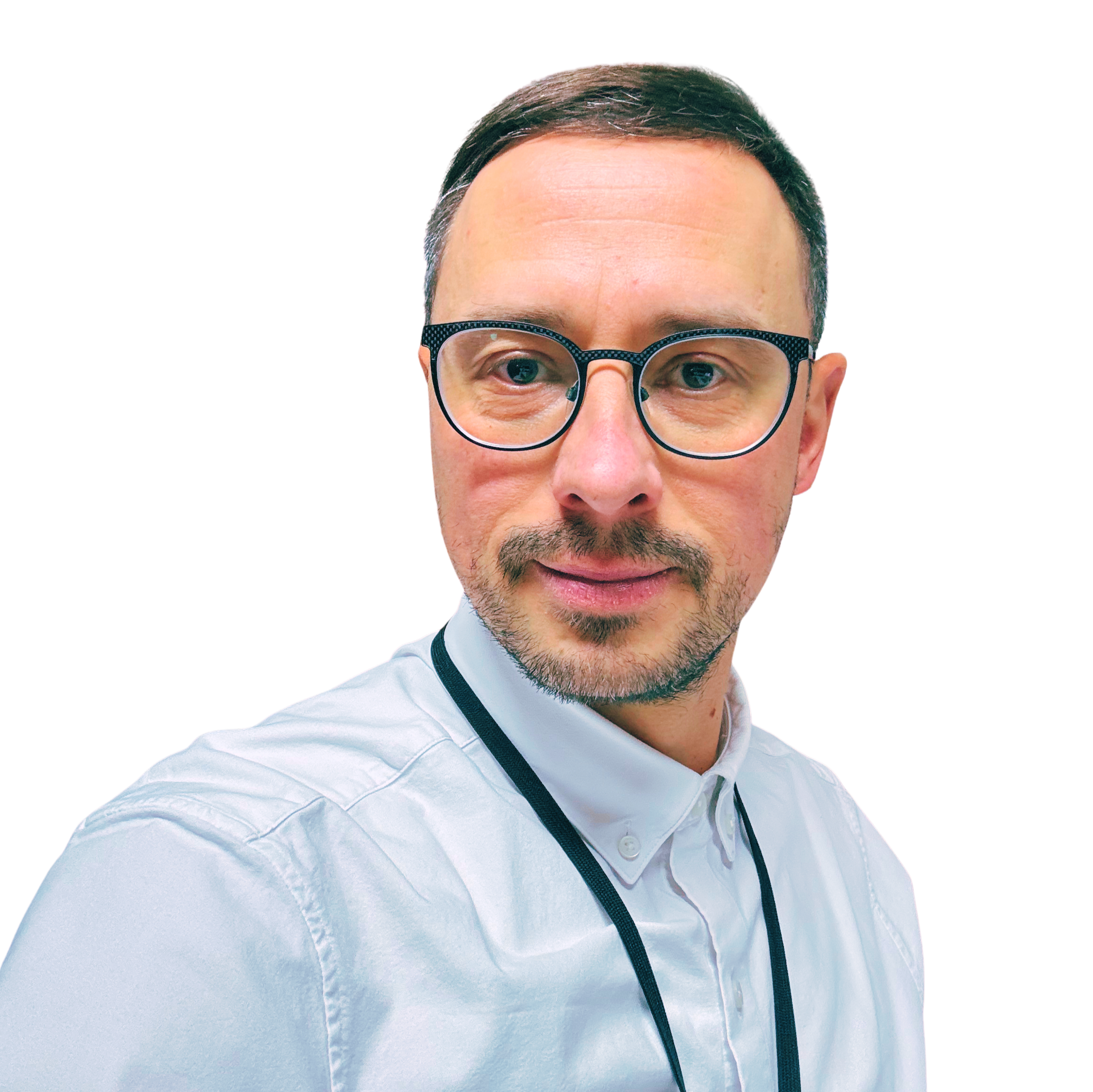Close-up of a man with glasses wearing a white shirt with dark trim, smiling, against a plain background.
