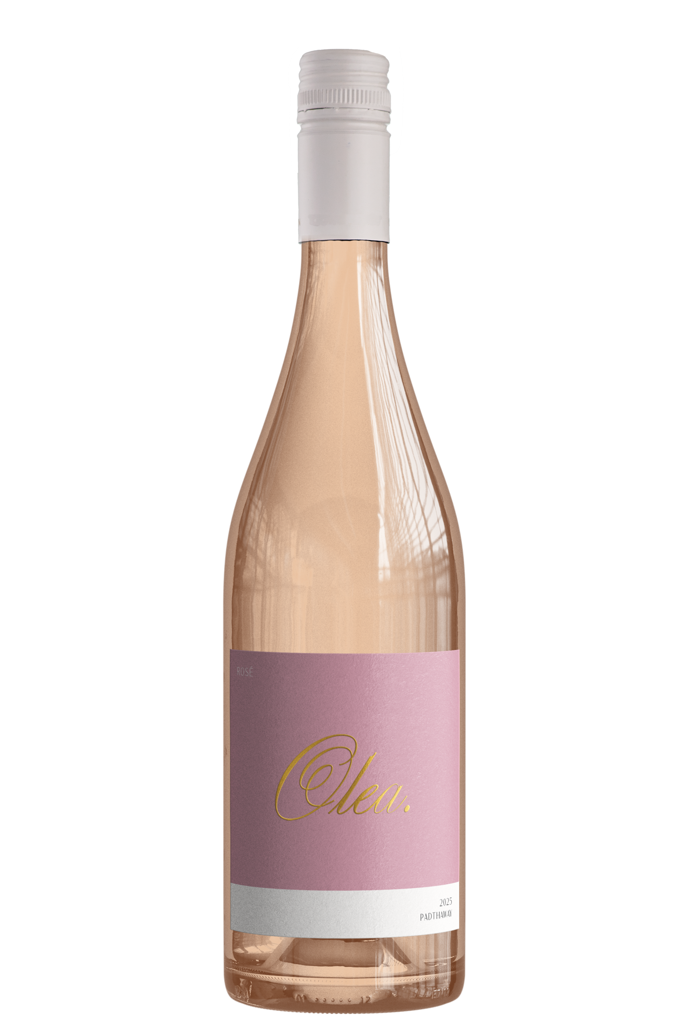 A clear glass bottle of rosé wine with a light pink label and gold cursive text, with a white screw cap, sitting on a reflective surface.