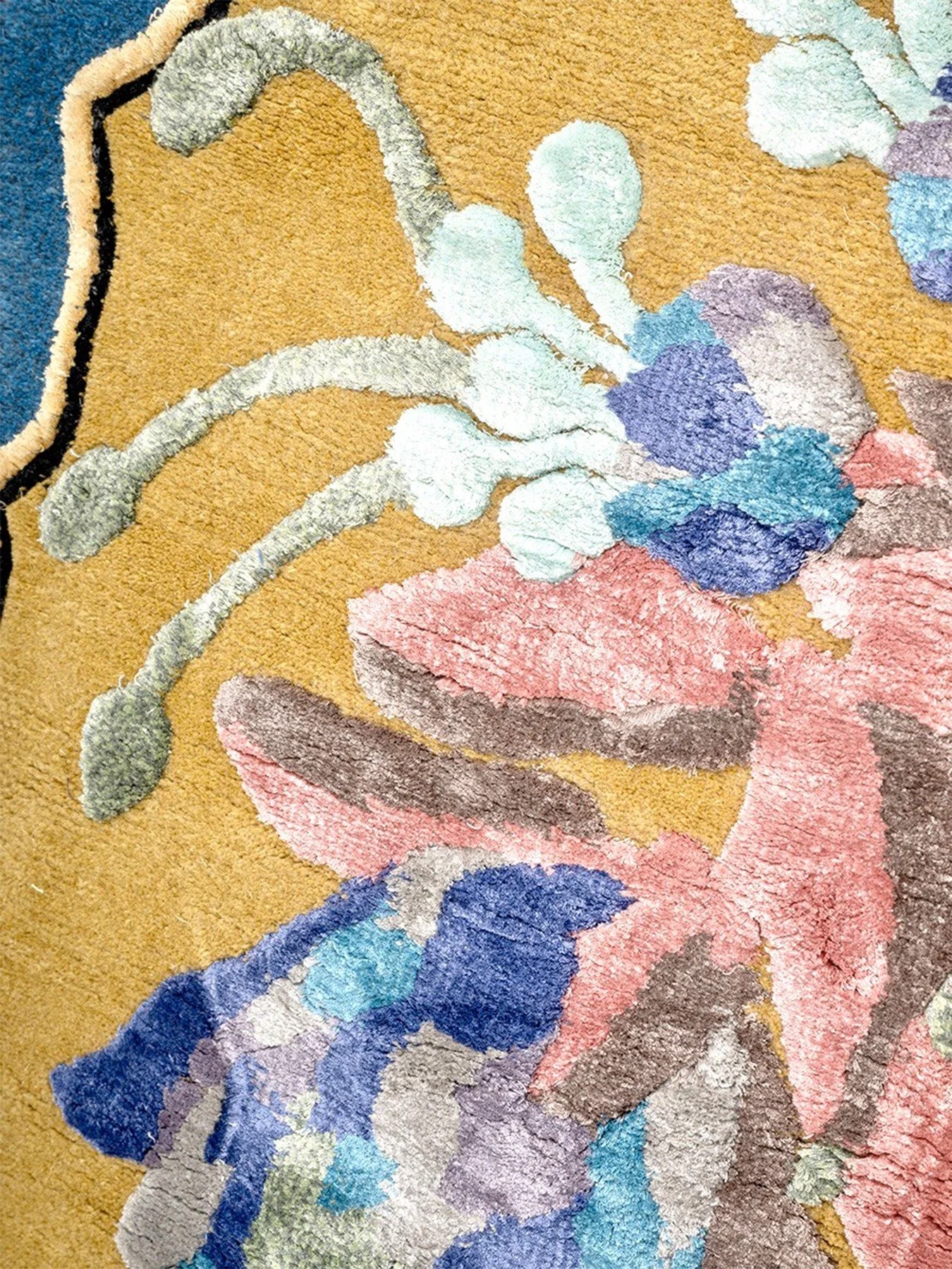 Close-up of a textured, colorful abstract painting on canvas with swirls and patches of blue, pink, purple, gray, and beige.