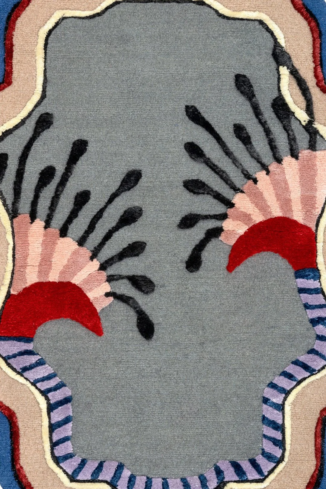 A colorful area rug with a pattern featuring stylized flowers with red, pink, and purple accents and a gray background.