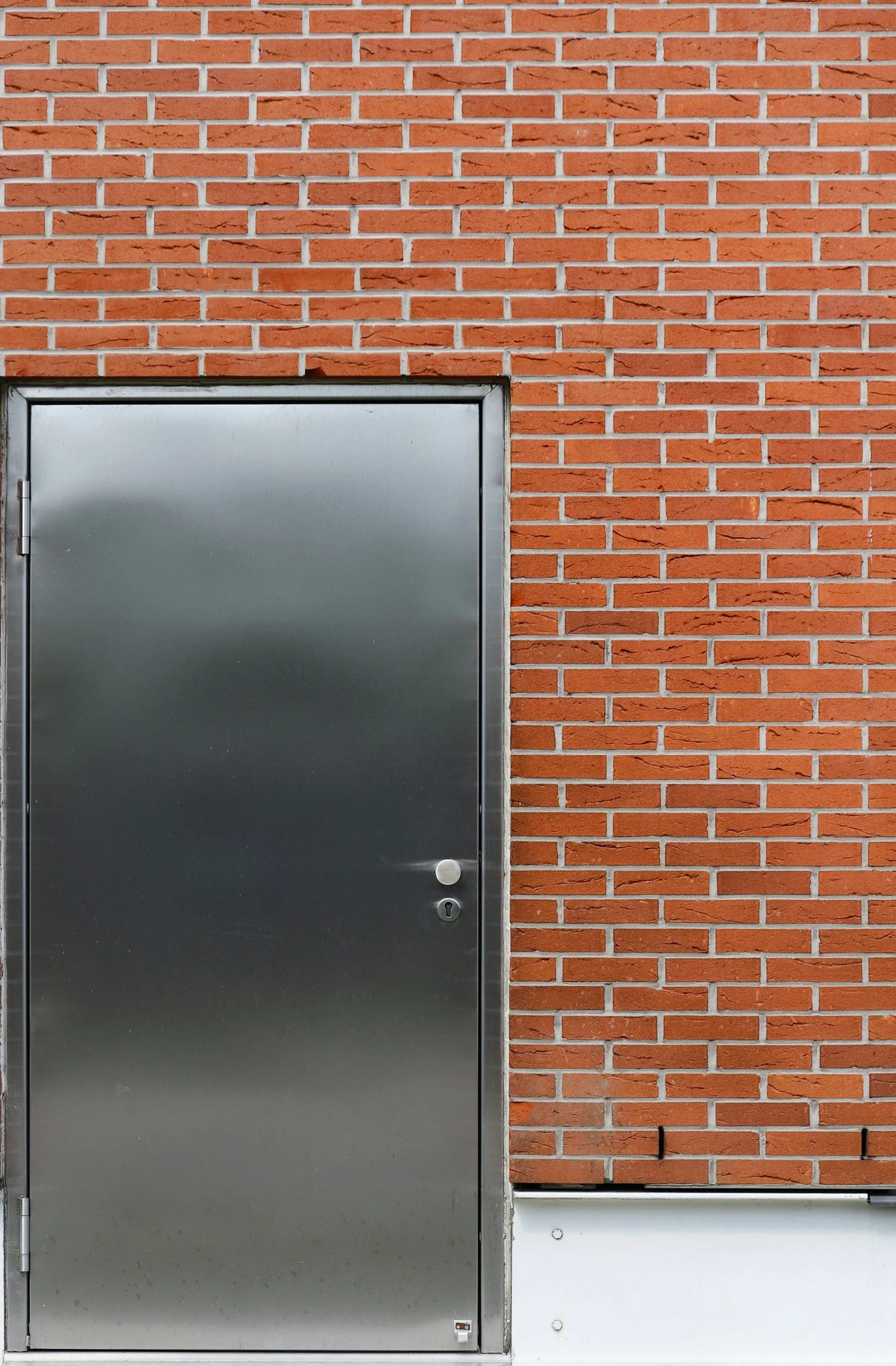Steel commercial door set in a red brick wall