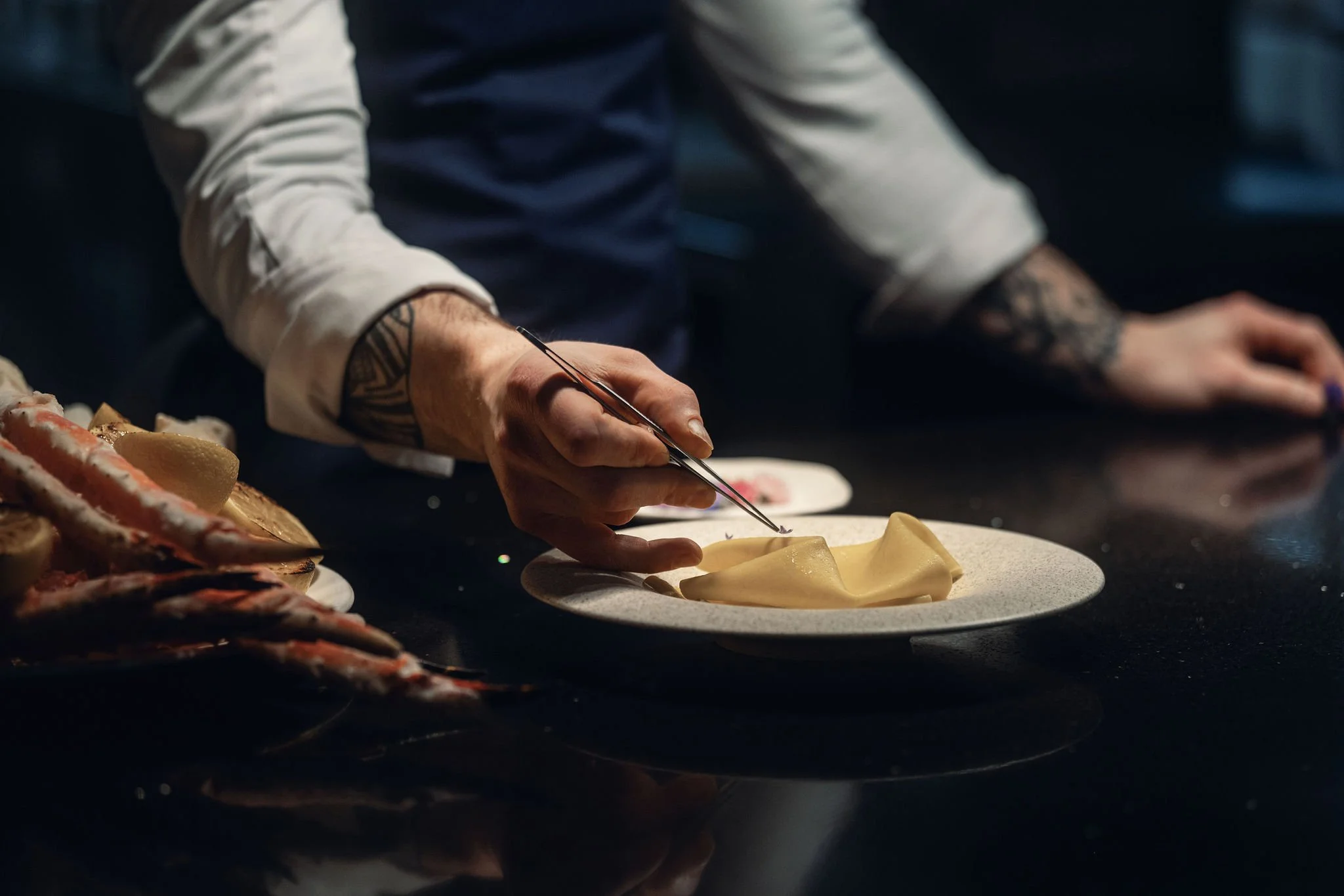 chef plating dish with tweezers