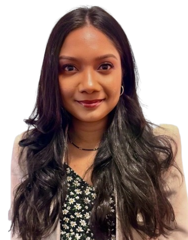 A woman with long, dark, wavy hair smiling, wearing a black floral top and a light-colored blazer.