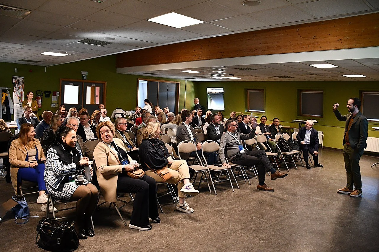 A speaker giving a presentation to an audience in a conference room EUHOFA Congress.