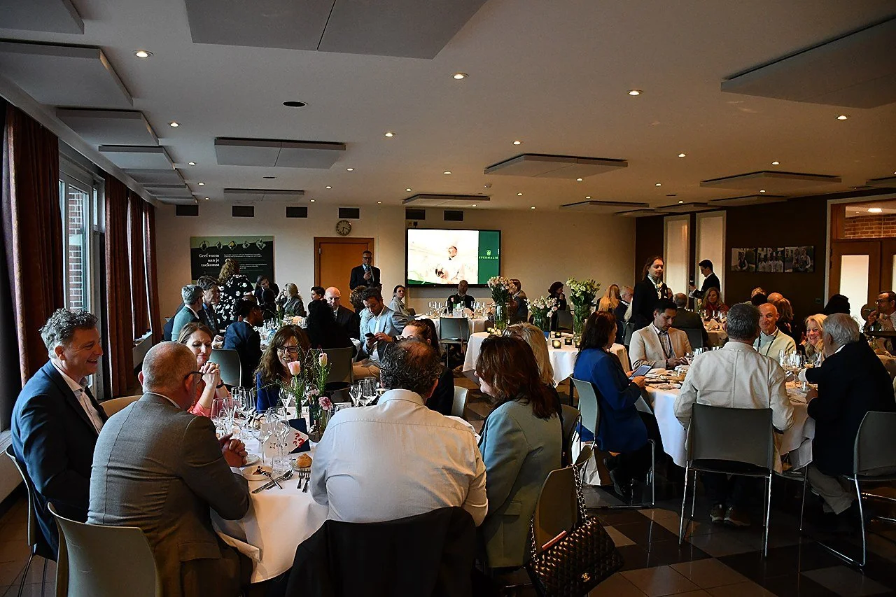 A large group of people gathered around tables at a formal event in a conference room at EUHOFA Congress.