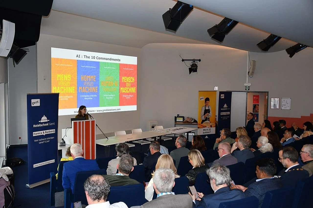 A conference room filled with attendees watching a speaker at a podium. A large screen behind the speaker displays 'AI: The 10 Commandments' with colorful sections. EUHOFA International Congress 2026.