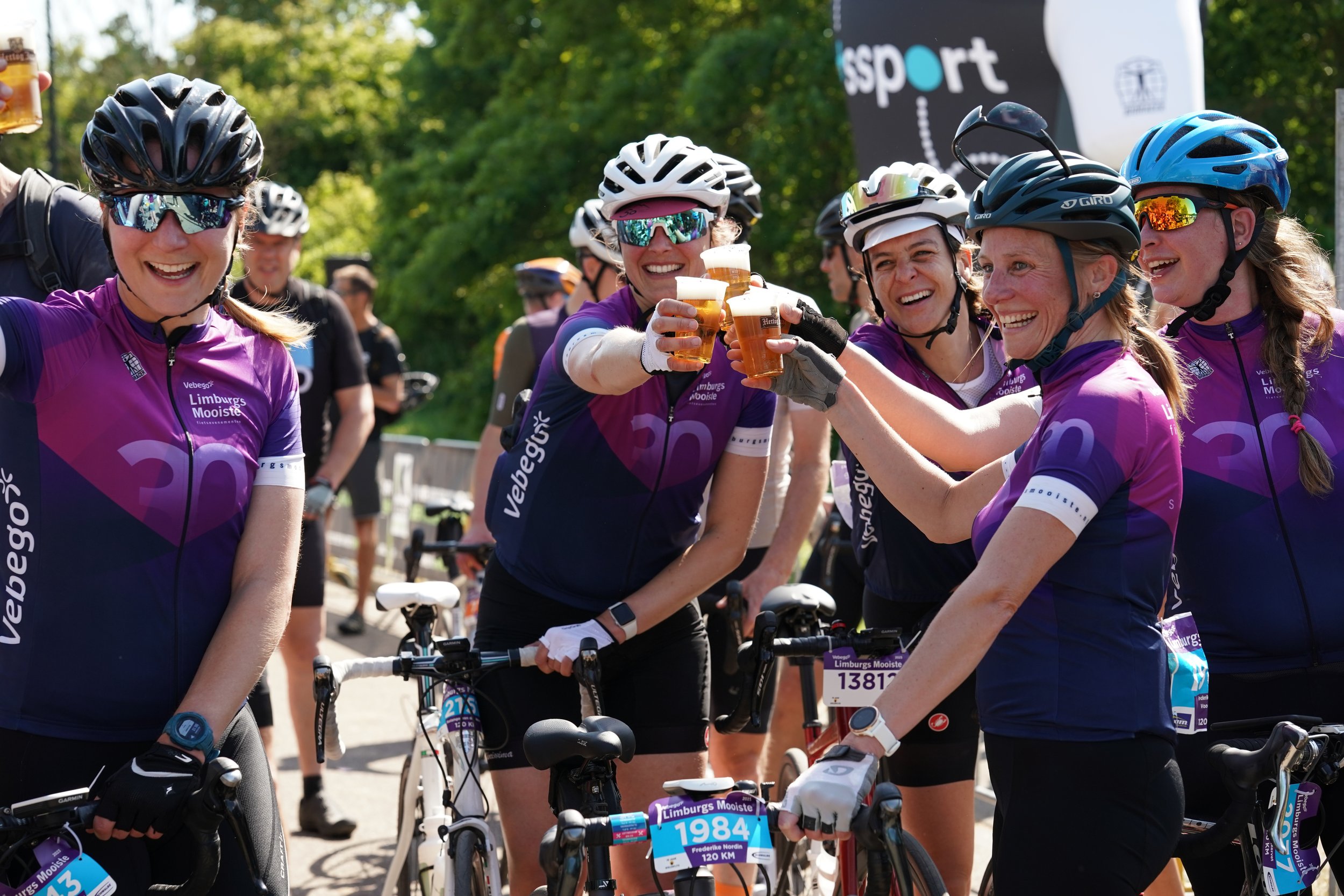 Cyclists enjoying a warm and social post-event gathering with drinks and conversation.
